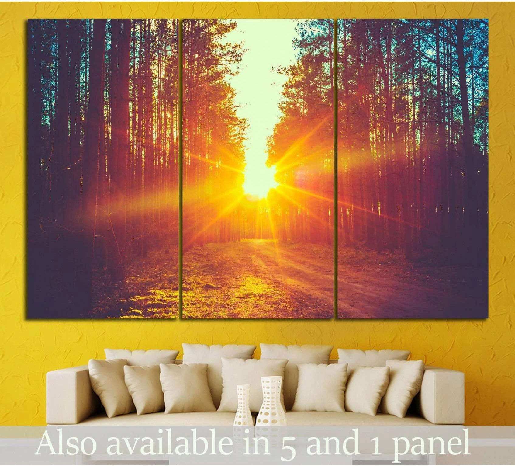 Sunrise forest canvas print with golden sunburst through tall trees above a sofa