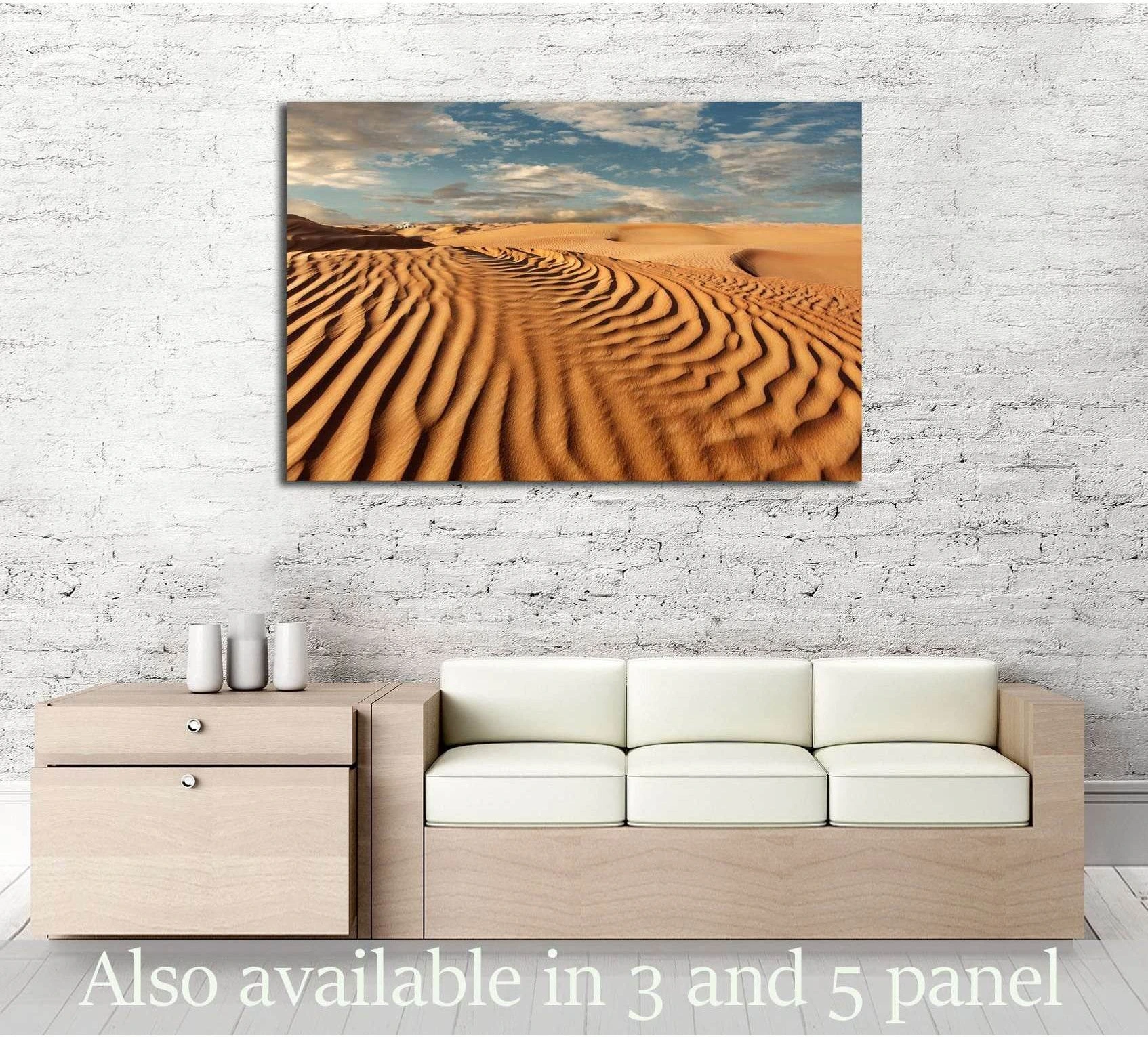 Desert sand dunes canvas print with rippled golden sand and blue sky above a sofa in a modern living room