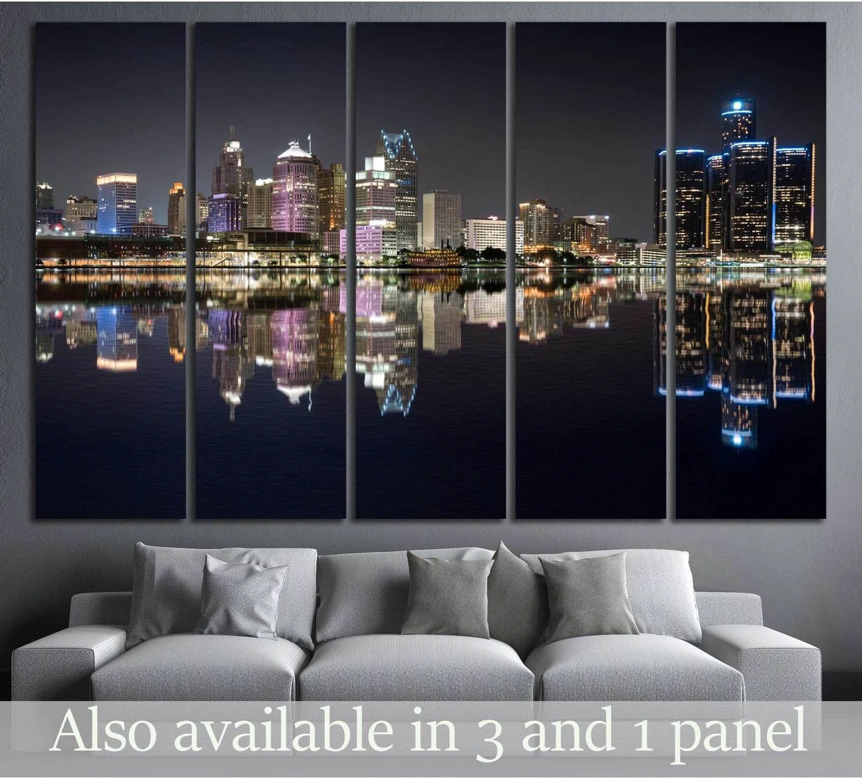 Detroit skyline canvas print with night city lights and river reflections, displayed above a gray sofa in a modern living room