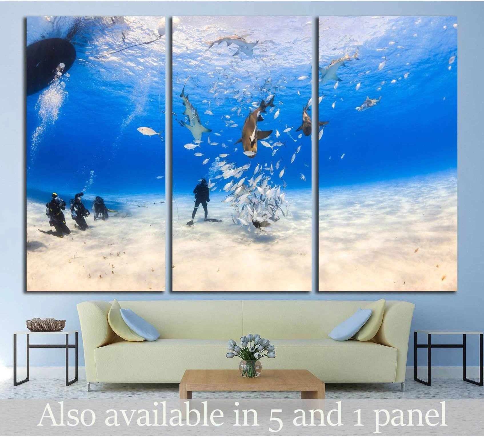 Diver surrounded by Lemon shark and caribbean reef shark on shallow clear water at Tiger beach, Bahamas showing sea water, shoreline and horizon depth.