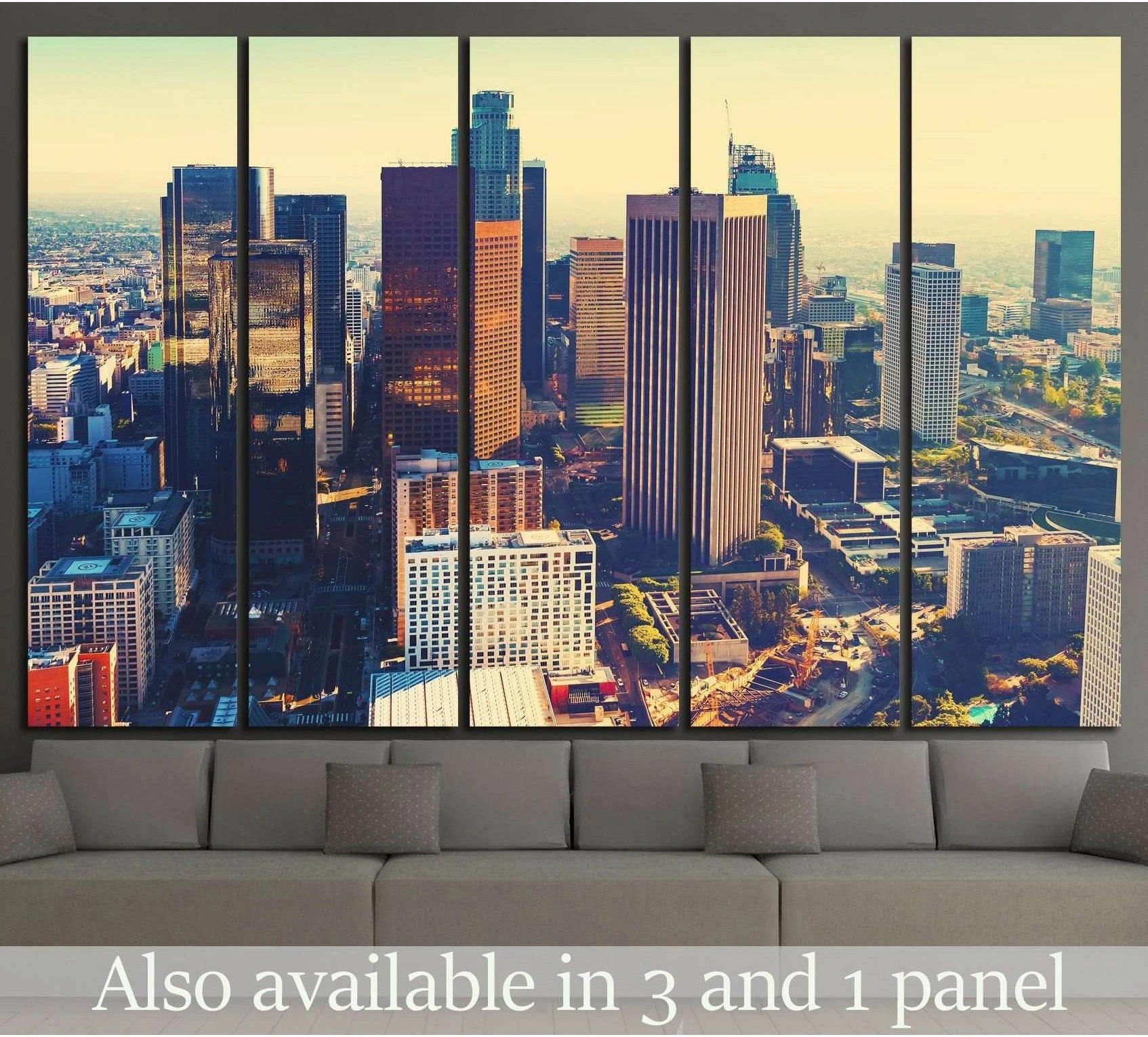 Downtown Los Angeles skyline canvas print in warm sunset tones hung above a gray sofa