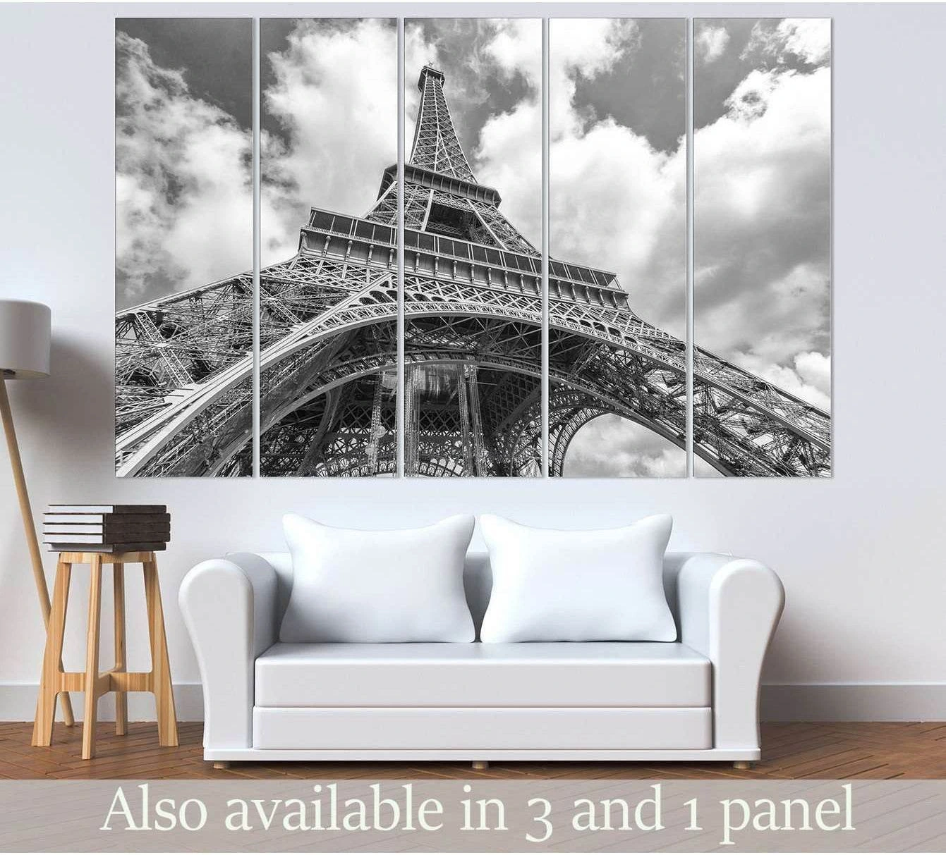 Black and white Eiffel Tower canvas print in five panels above a sofa in a modern living room