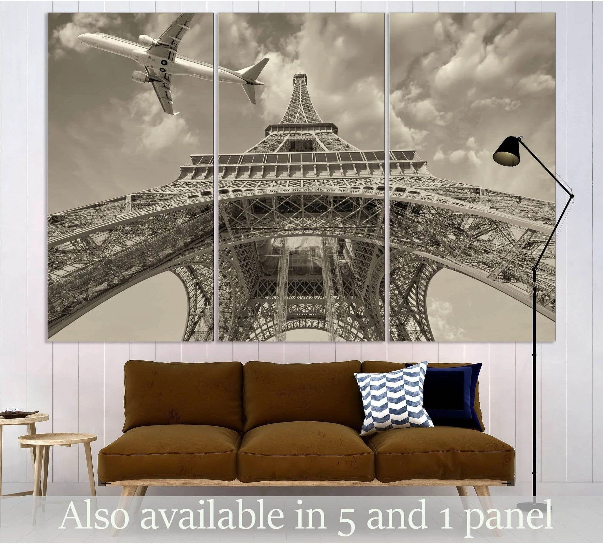 Sepia Eiffel Tower canvas print with airplane overhead in a triptych above a brown sofa