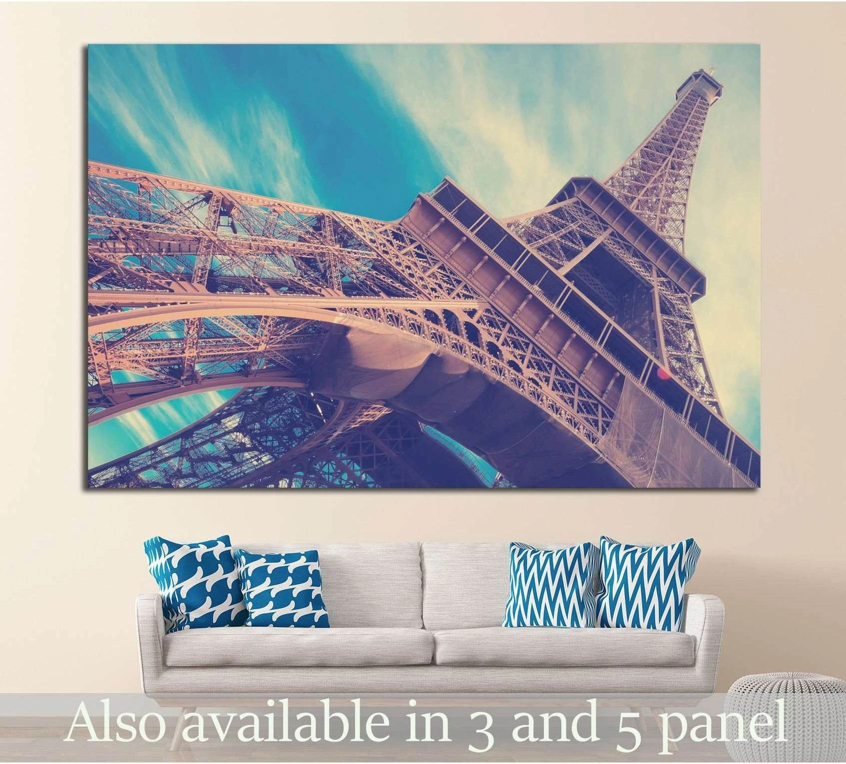 Low-angle Eiffel Tower canvas print in pastel teal sky above sofa in modern living room