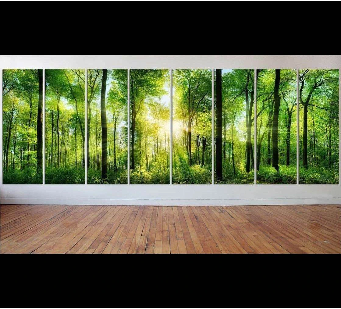Sunlit green forest panoramic canvas print hung across a modern wall in a bright living room