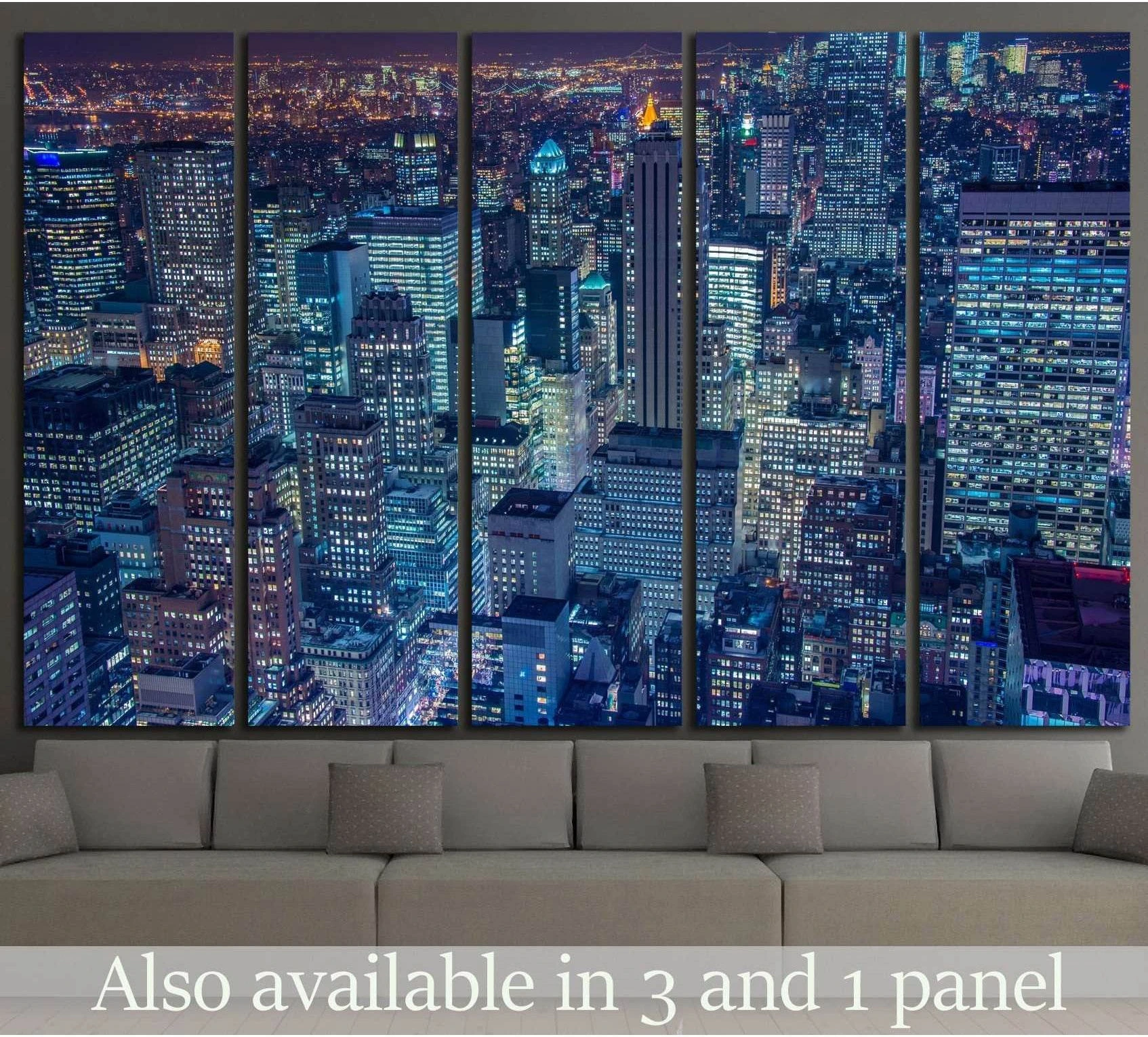New York night skyline canvas print in five panels above a sofa with blue-lit skyscrapers