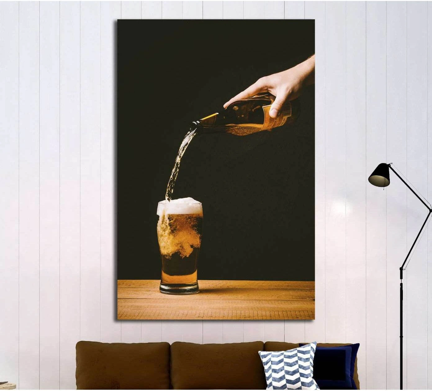 Amber beer pour canvas print with hand pouring from bottle into foamy glass on dark background