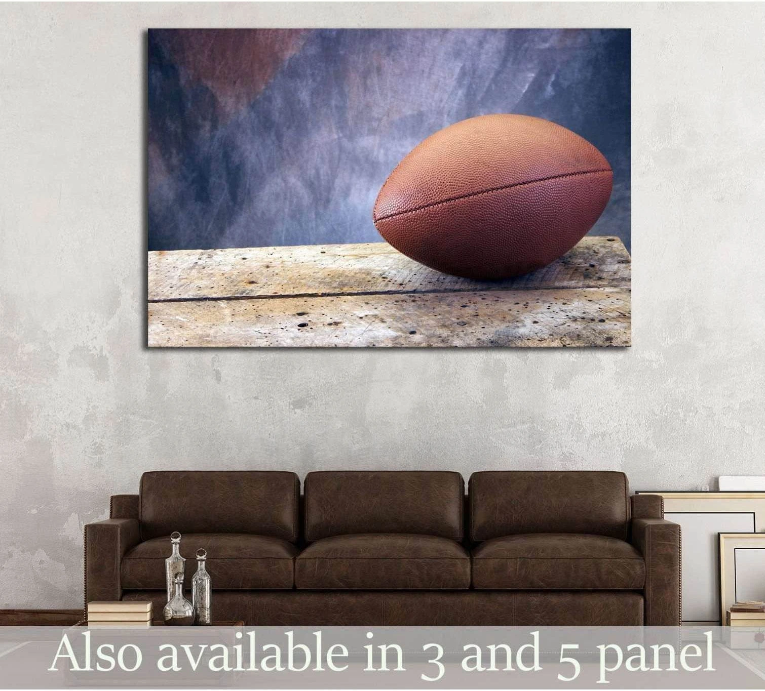 Football canvas print on weathered wood table hung above sofa in a rustic game room