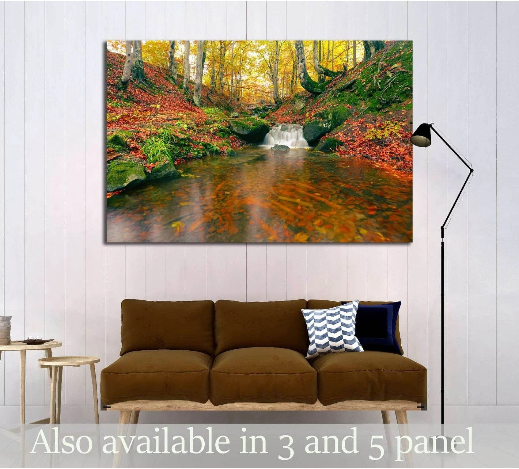 Autumn forest waterfall canvas print above a brown sofa in a modern living room