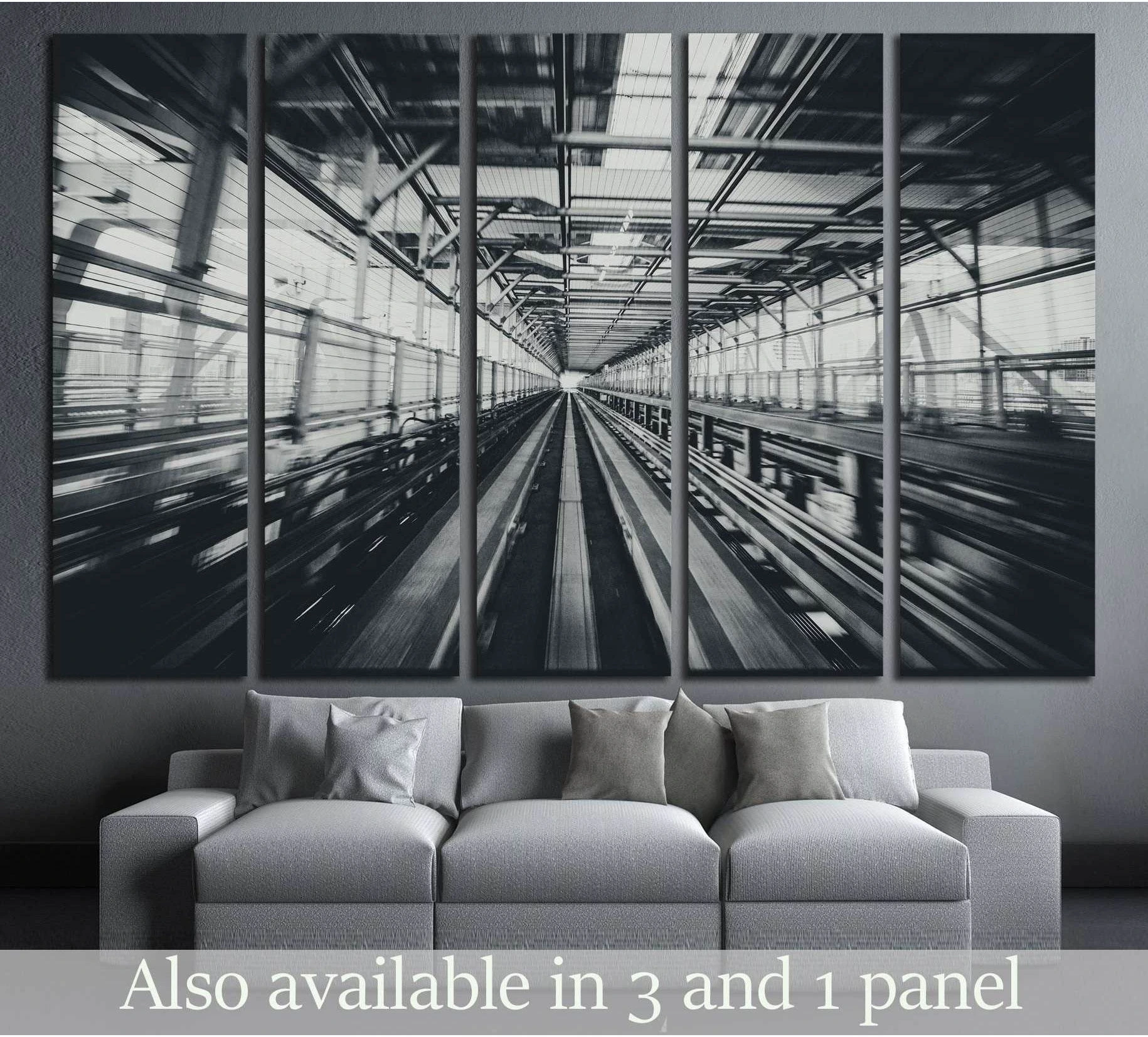 Black and white train tunnel canvas print with motion blur above sofa in a modern living room
