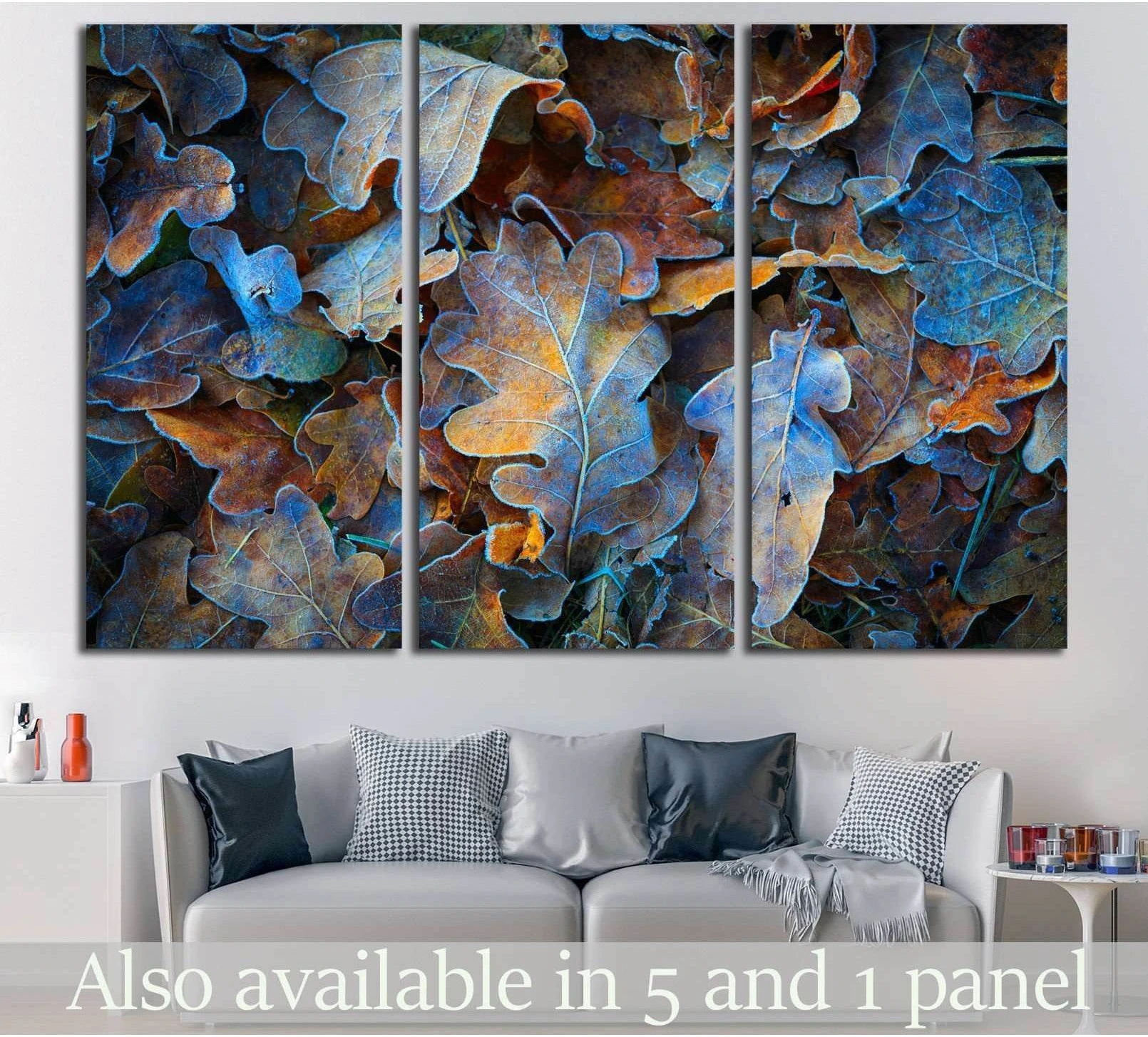 Frosted oak leaves triptych canvas print with blue and copper autumn tones above a sofa in a modern living room