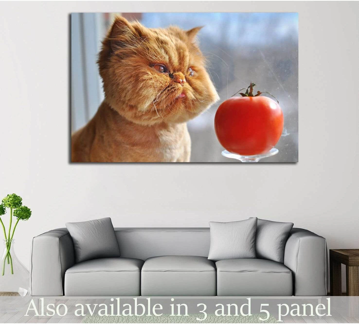 Ginger cat canvas print with a red tomato, displayed above a sofa in a modern living room