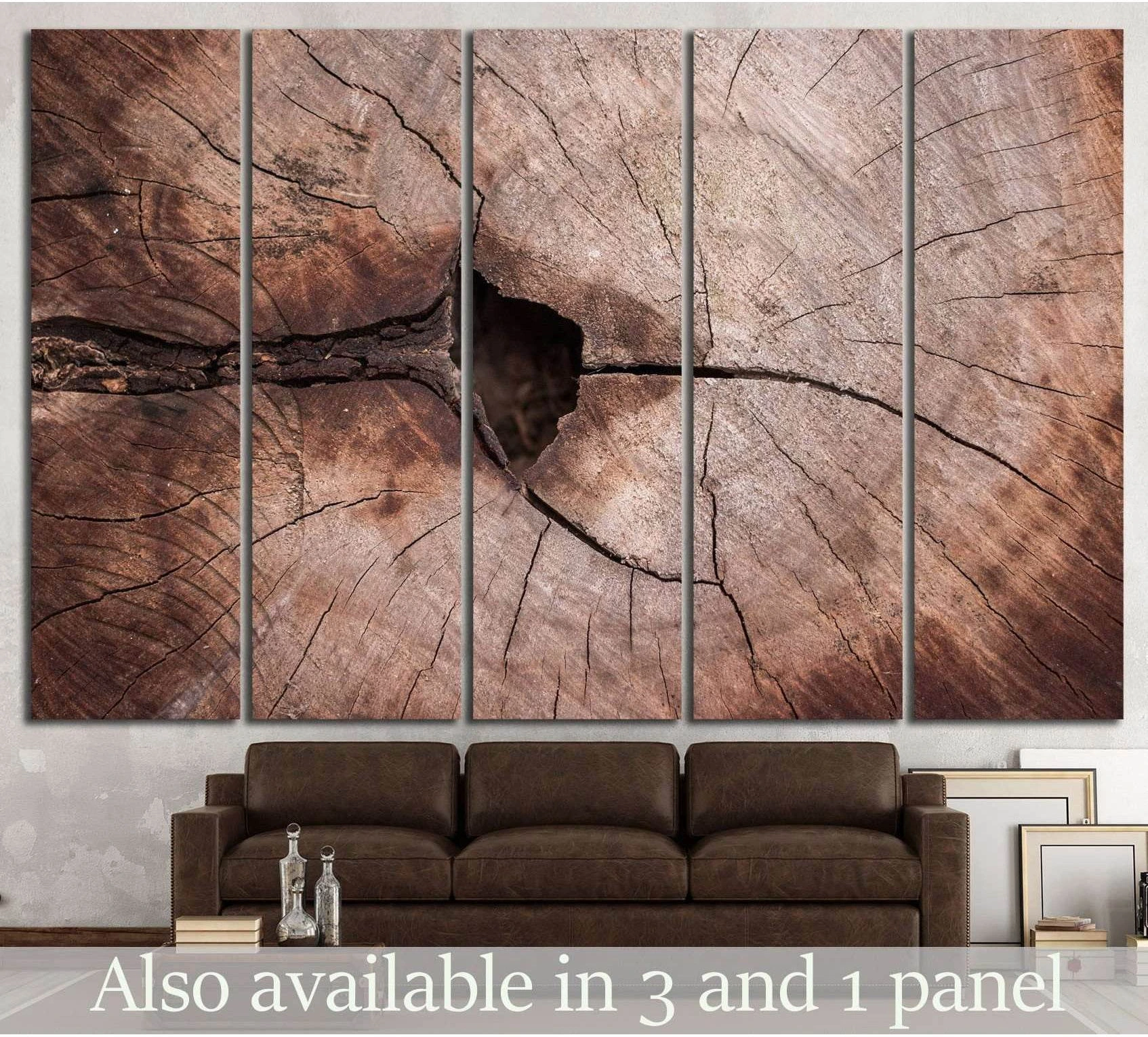 Tree ring canvas print with cracked heartwood detail above a brown sofa in a rustic living room
