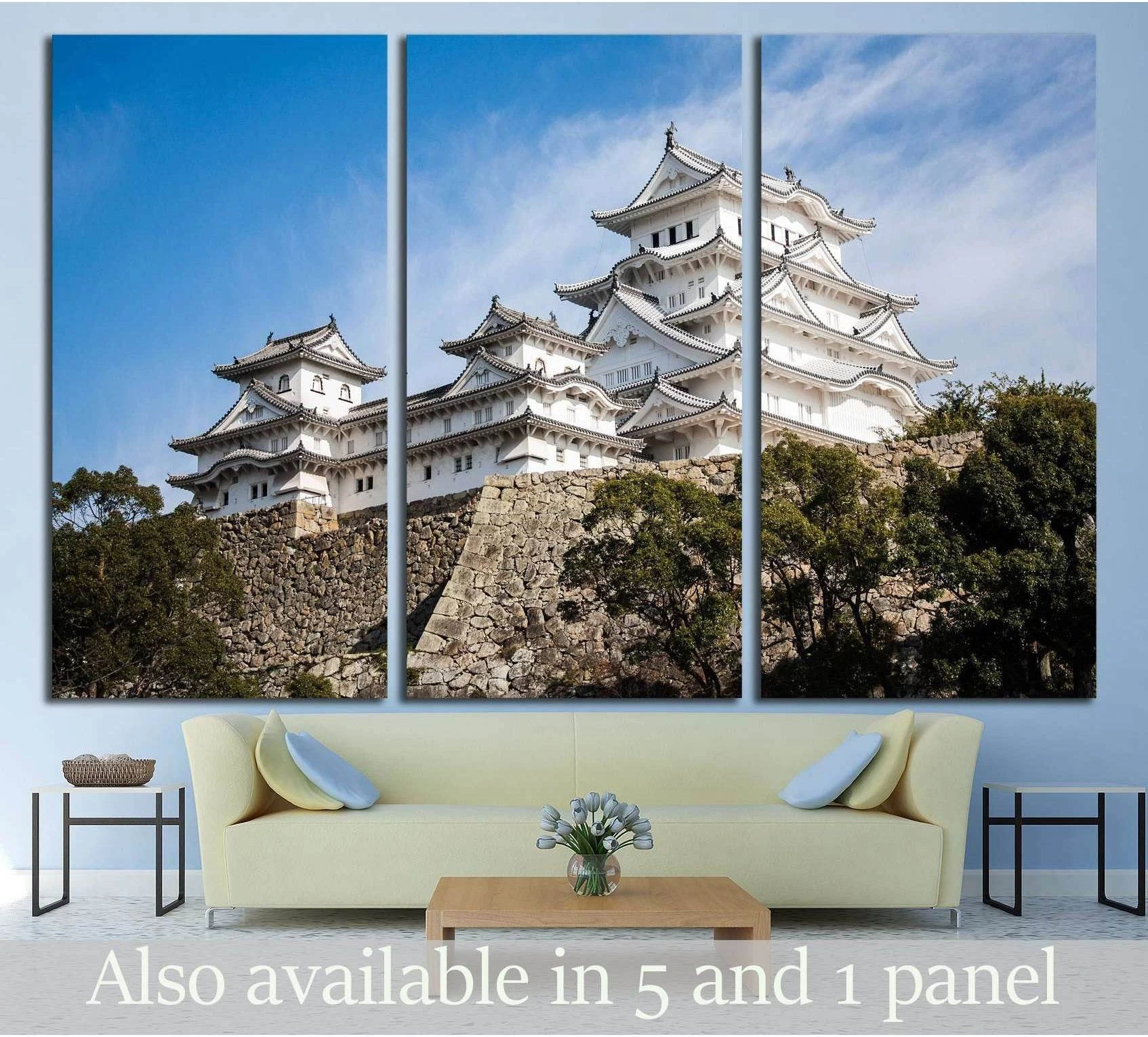Himeji Castle canvas print in a three-panel mockup above a sofa with blue sky and white castle architecture