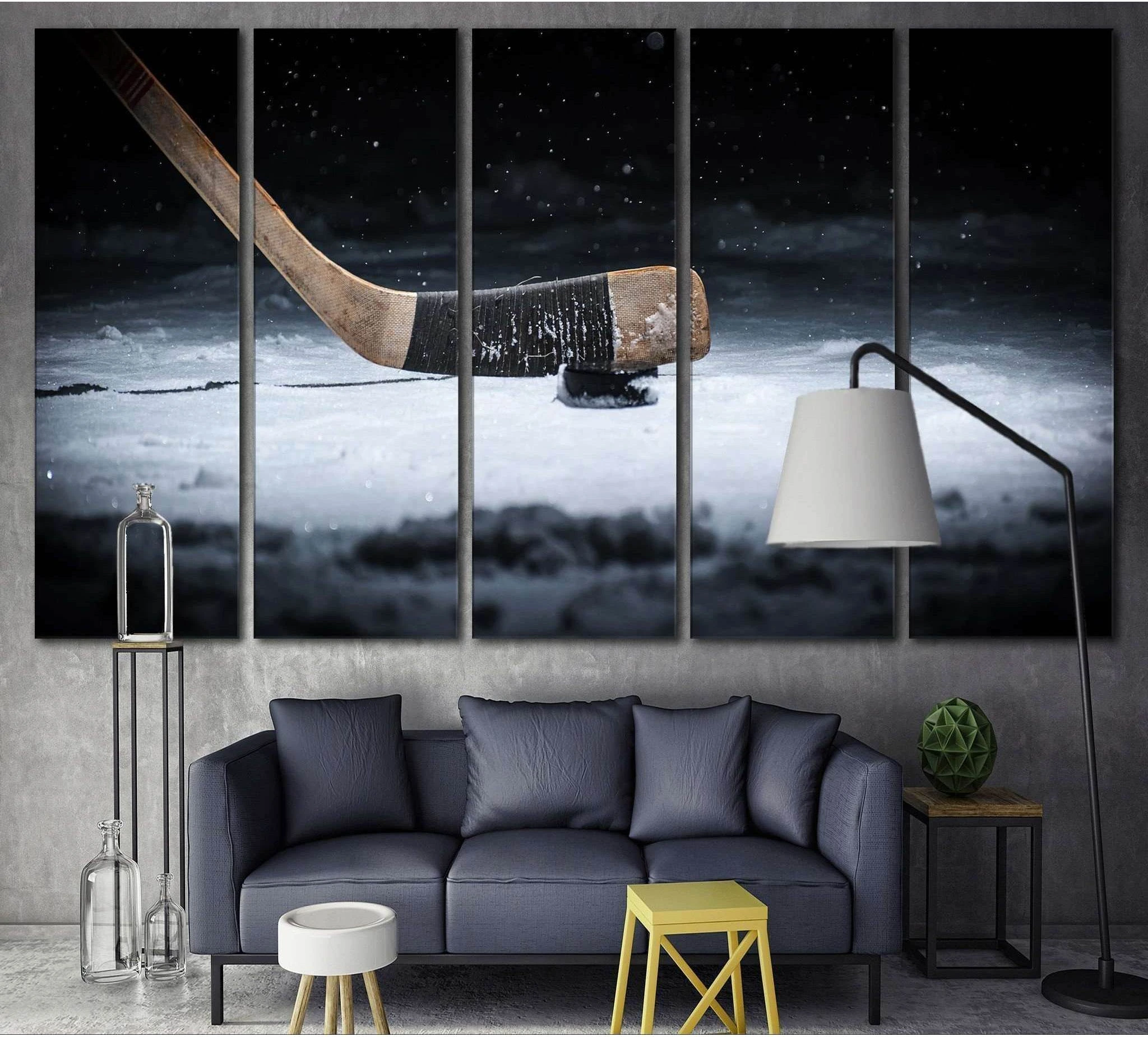 Five-panel hockey canvas print with stick and puck on ice above a sofa in a modern living room