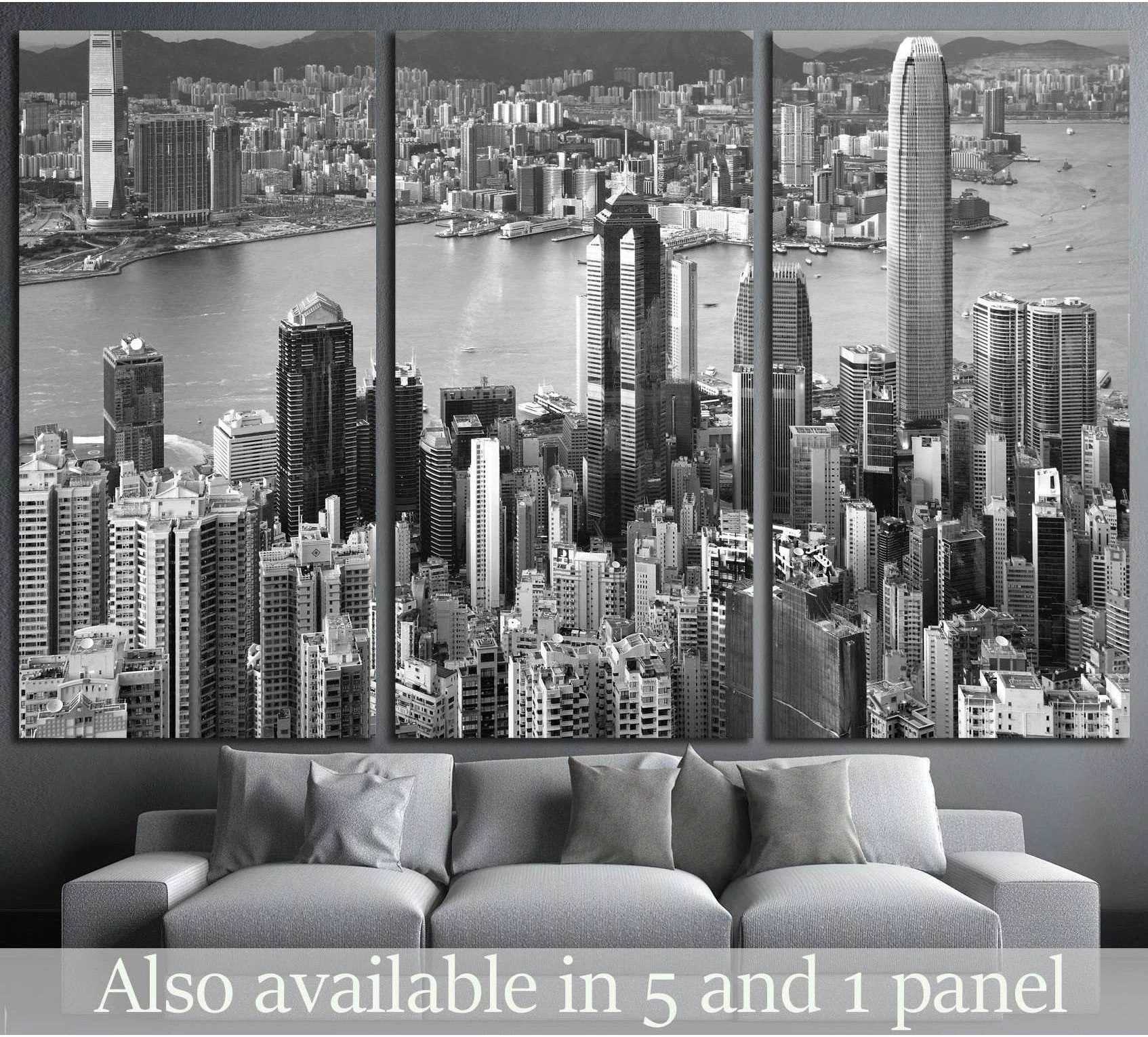 Black and white Hong Kong skyline canvas print in triptych layout above a grey sofa