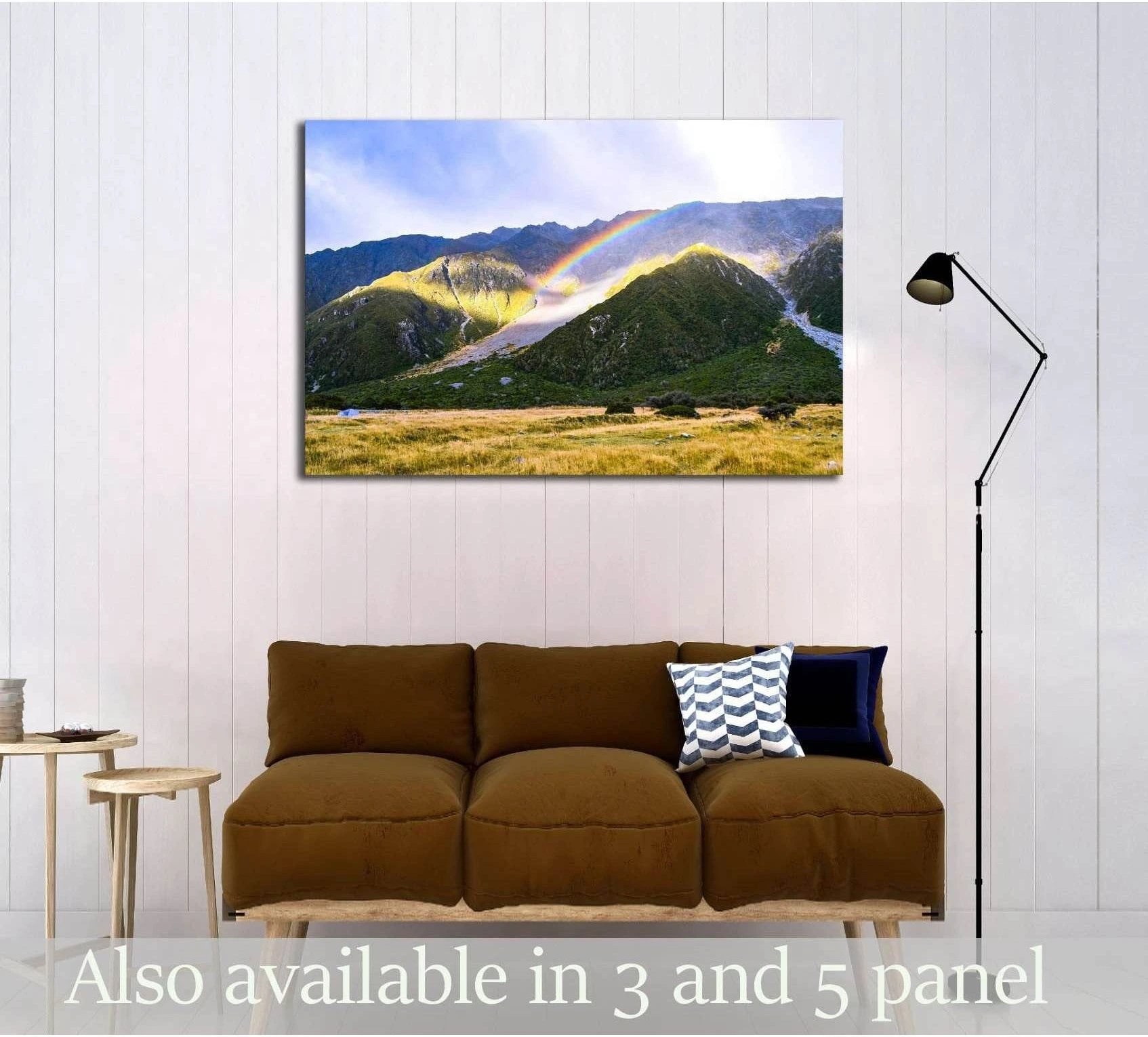 Hooker Valley mountain canvas print with rainbow over alpine meadow, displayed above a sofa in a modern living room
