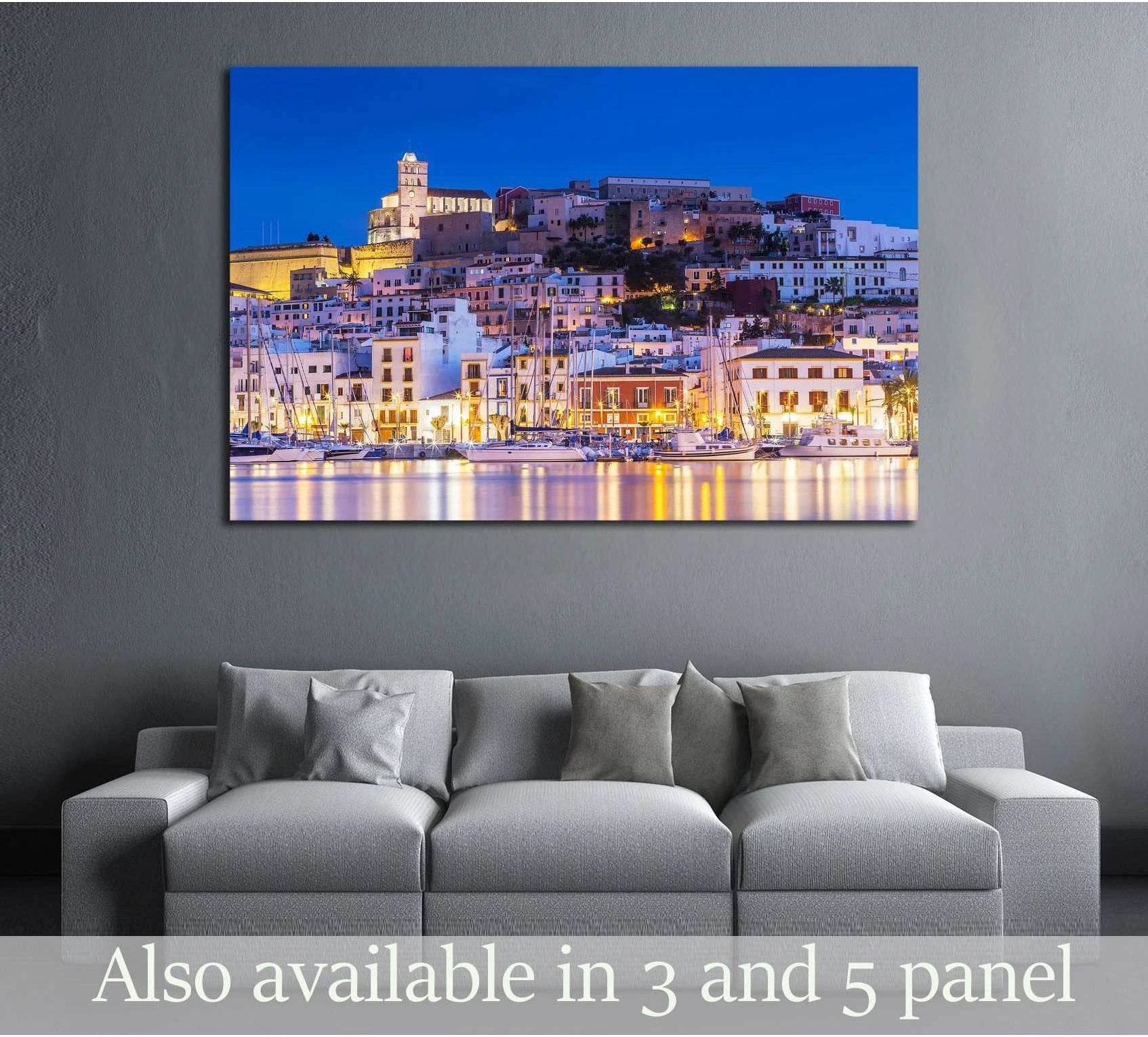 Ibiza Dalt Vila canvas print at night with harbor reflections above a sofa in a modern living room