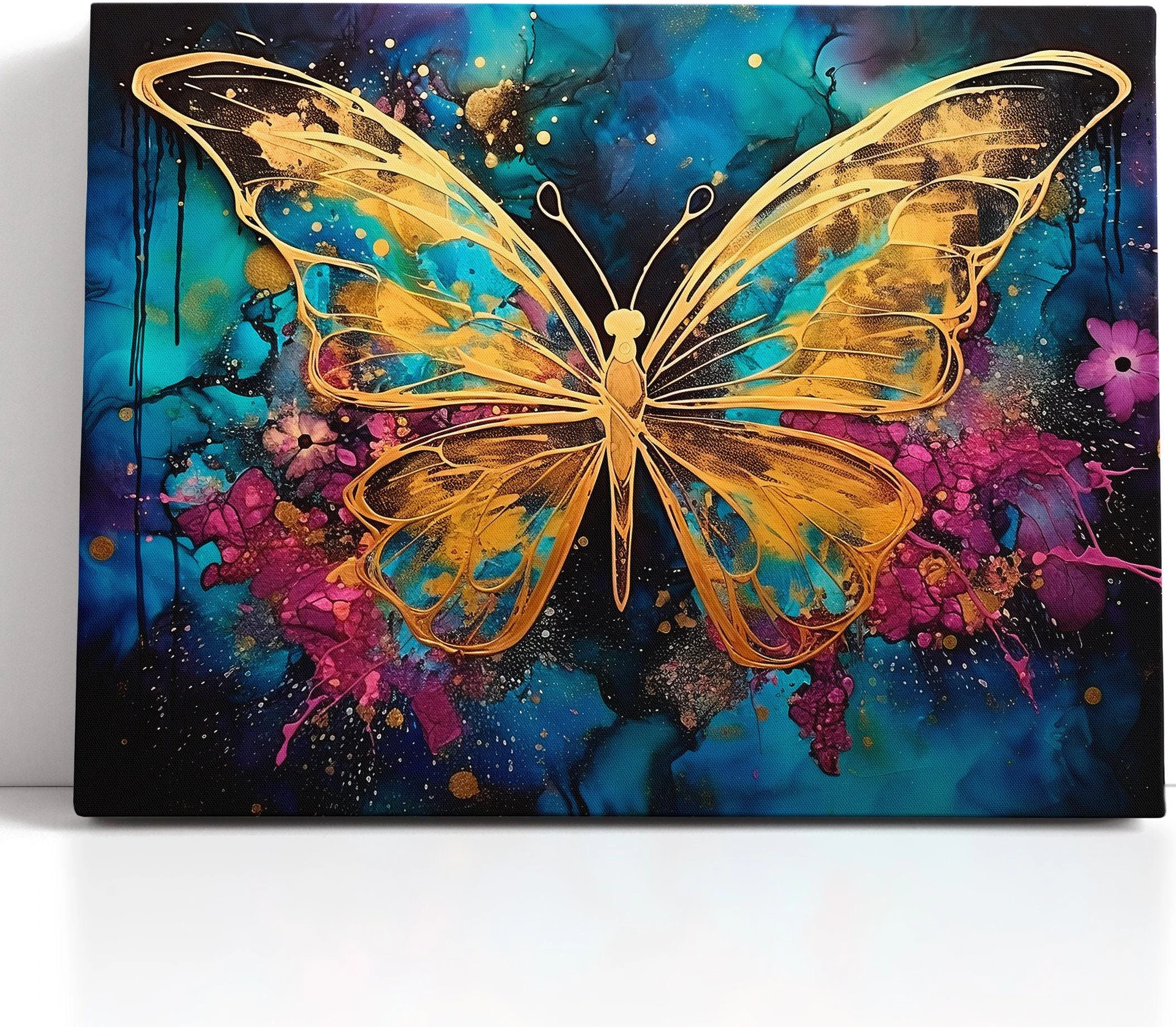 Abstract gold butterfly on a teal, blue and magenta splash background with glitter-like speckles detail view