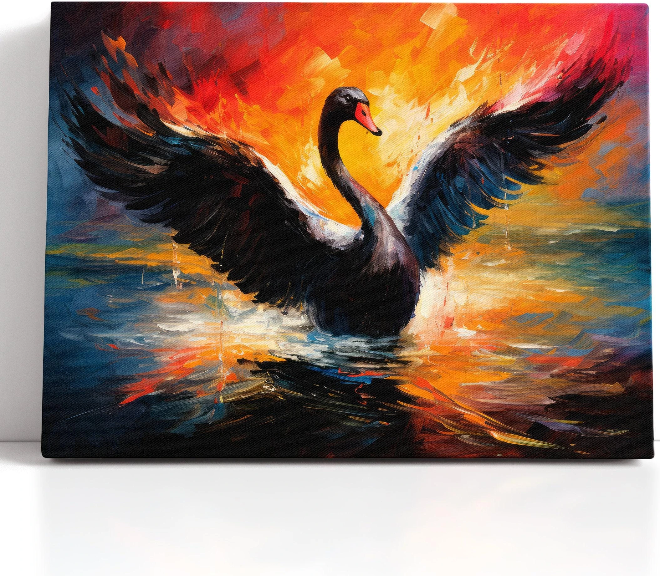 Black swan with wings spread over choppy blue water and fiery orange sunset light detail view
