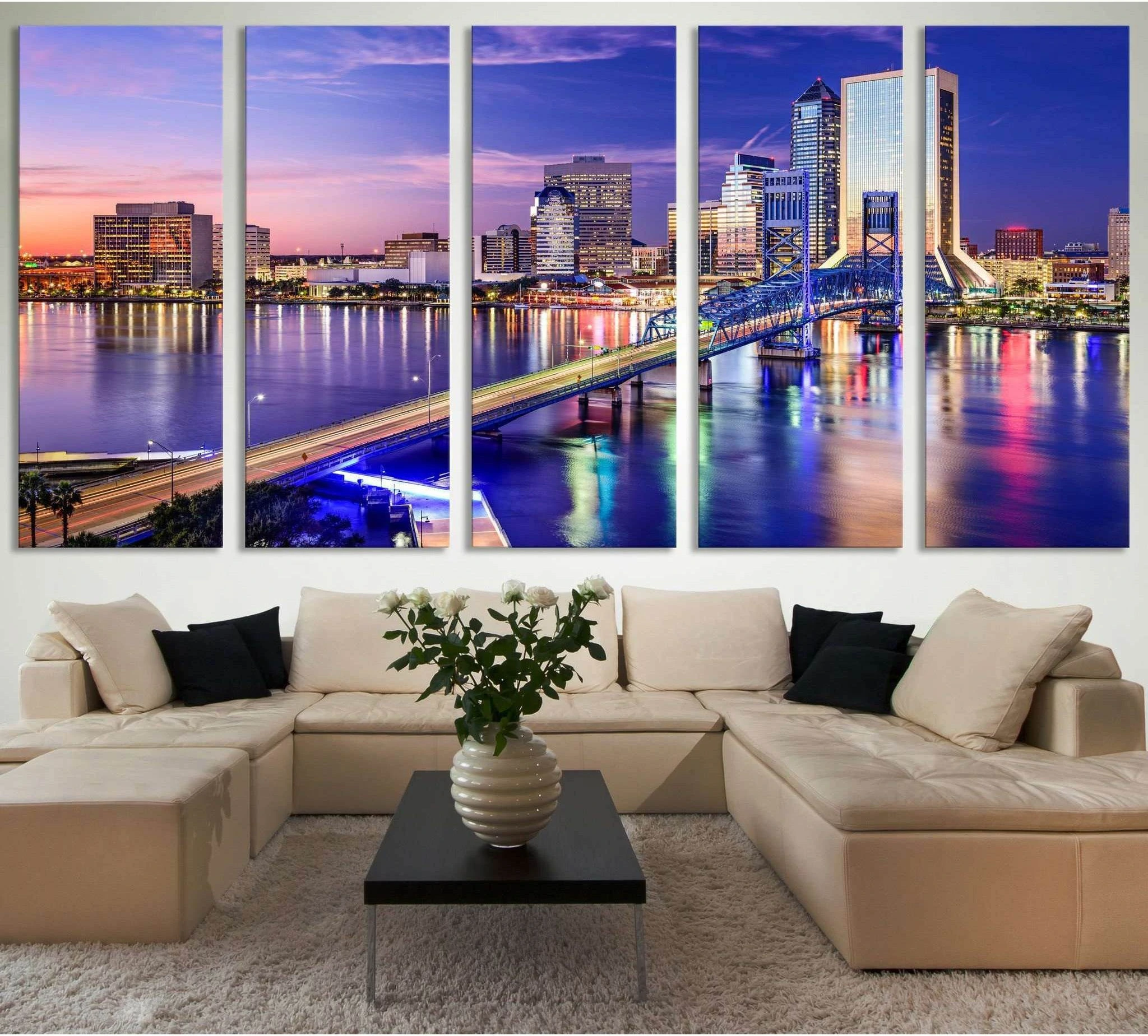 Jacksonville skyline canvas print with blue-lit bridge over river displayed above sofa in a modern living room
