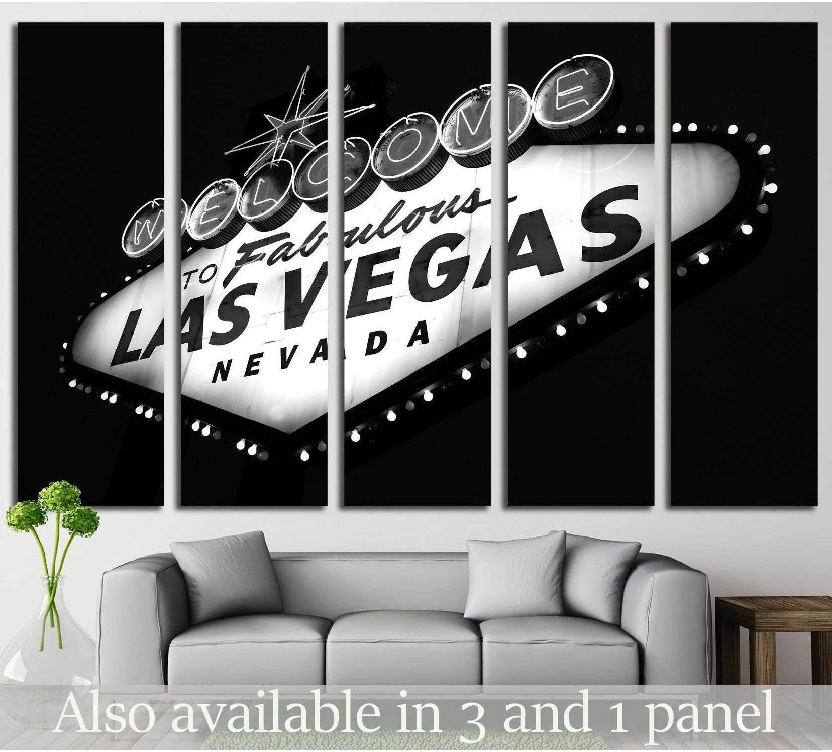 Black and white Las Vegas sign triptych canvas print above a gray sofa in a modern living room