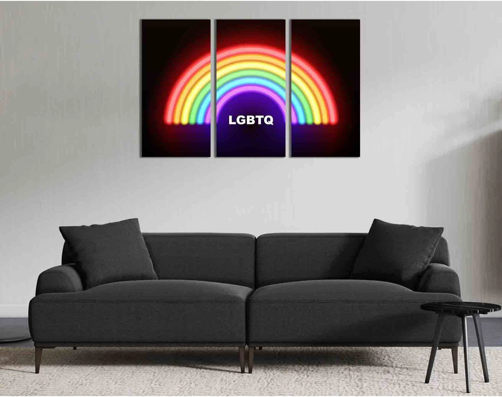 Neon rainbow LGBTQ text artwork on a black background across three canvas print panels above a modern sofa