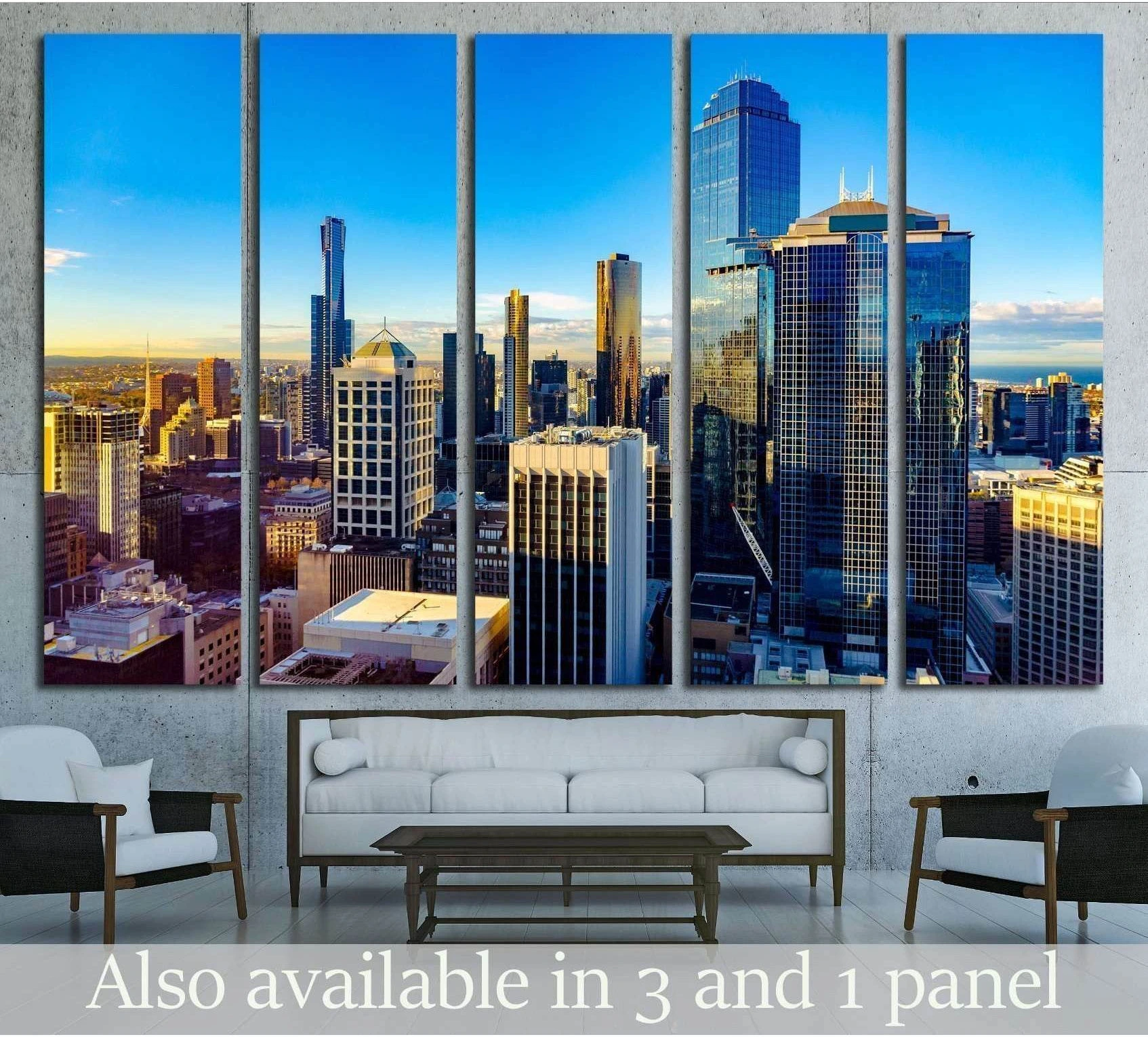 Melbourne skyline canvas print with glass skyscrapers at sunrise above a sofa in a modern living room