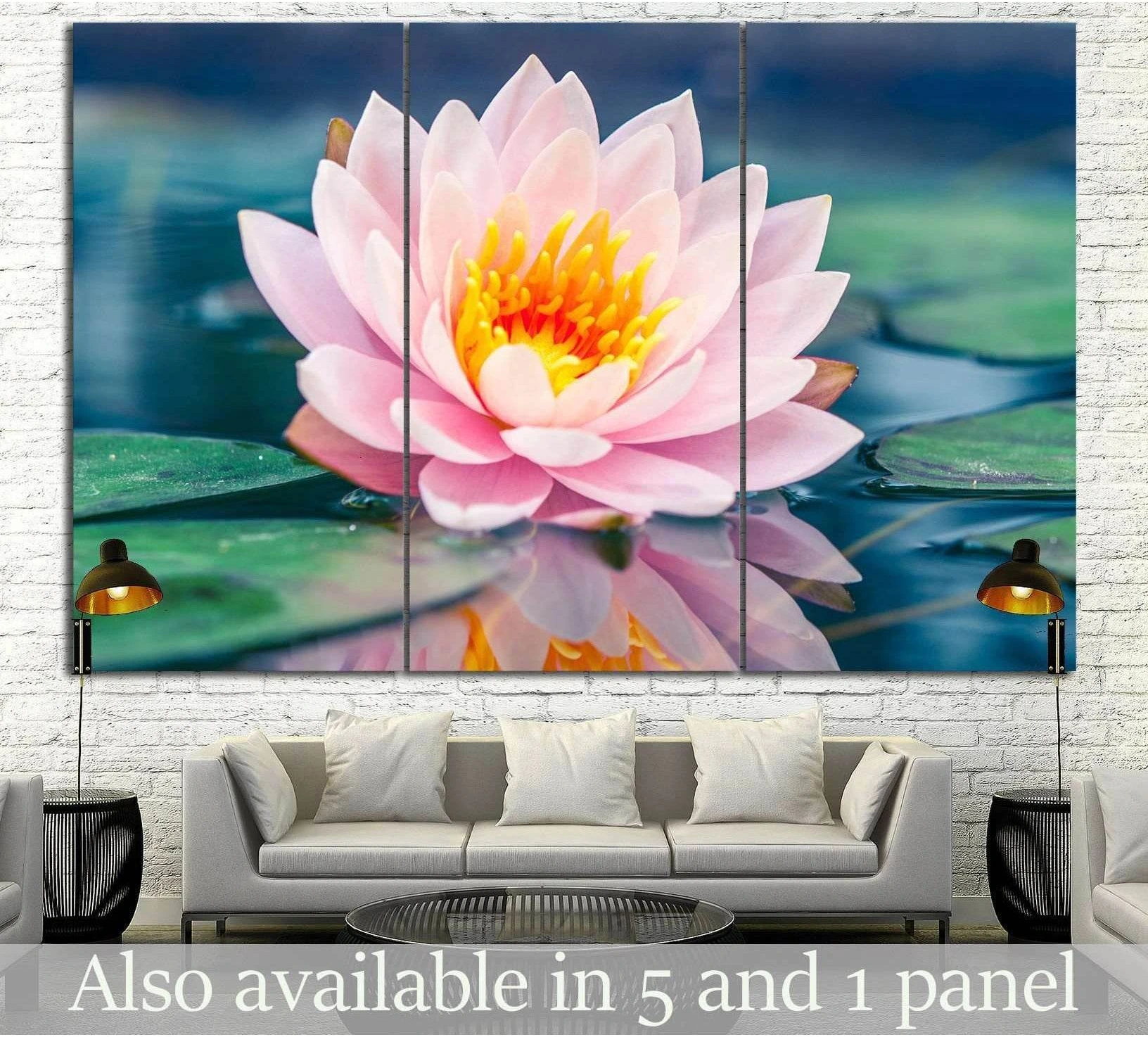 Pink lotus flower canvas print with water reflection and lily pads, displayed above sofa in a modern living room