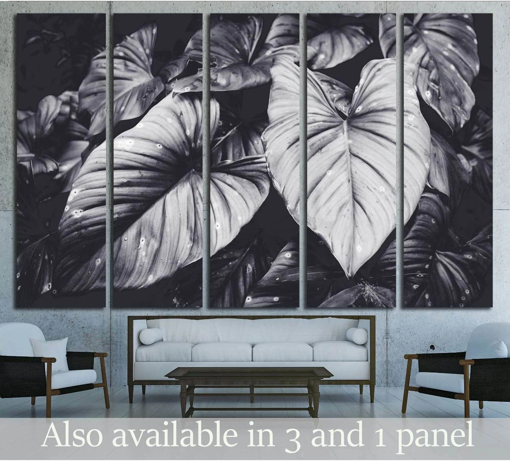 Black and white tropical leaves canvas print hung above a sofa in a modern living room
