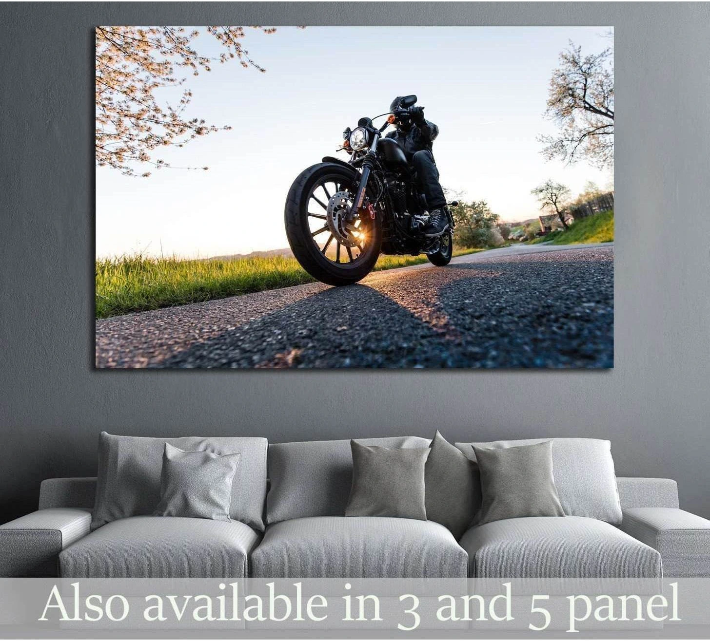 Low-angle motorcycle sunrise canvas print with rider on country road, hung above a sofa