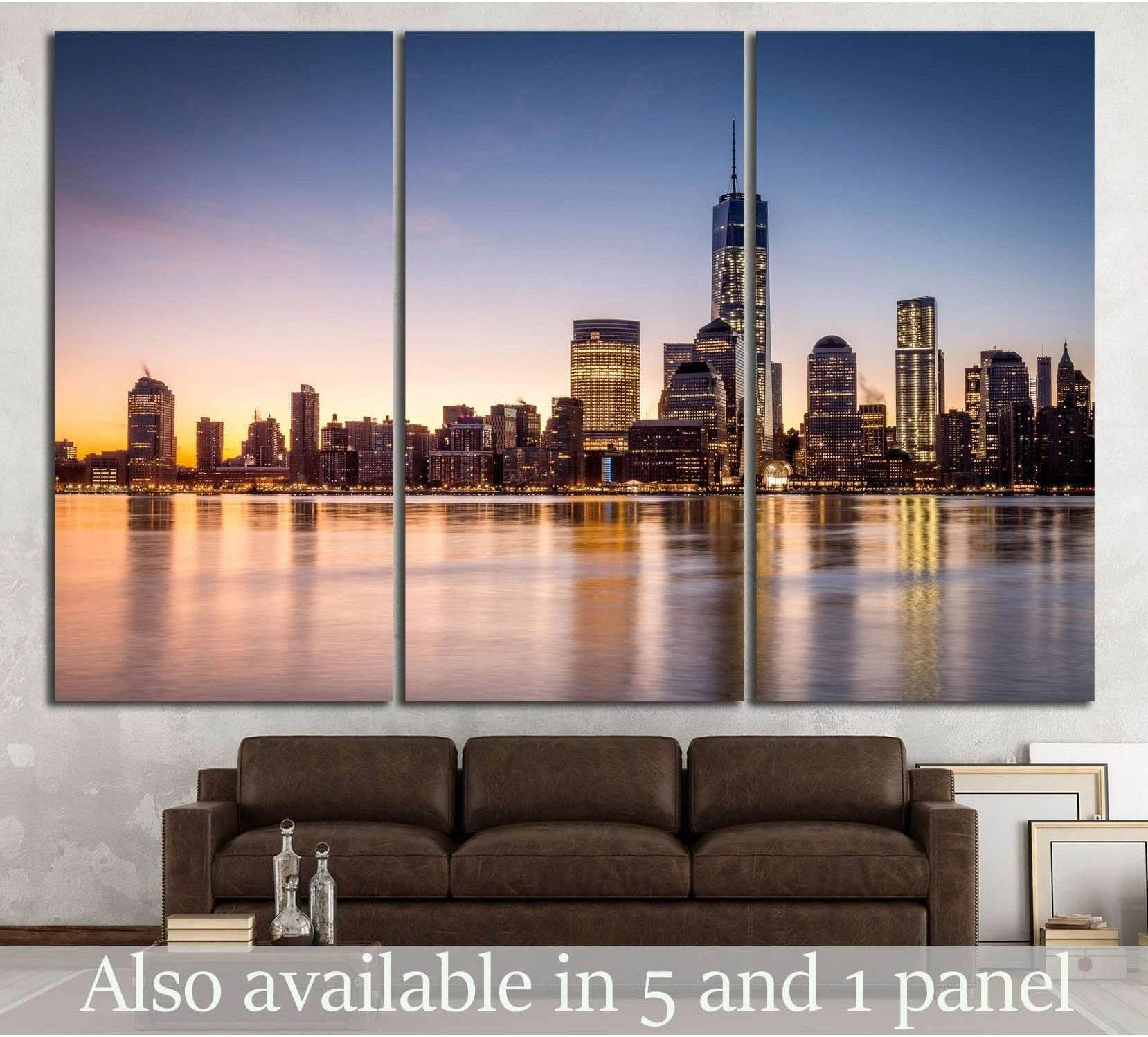 Manhattan skyline triptych canvas print at sunset with One World Trade Center above calm water in a modern living room