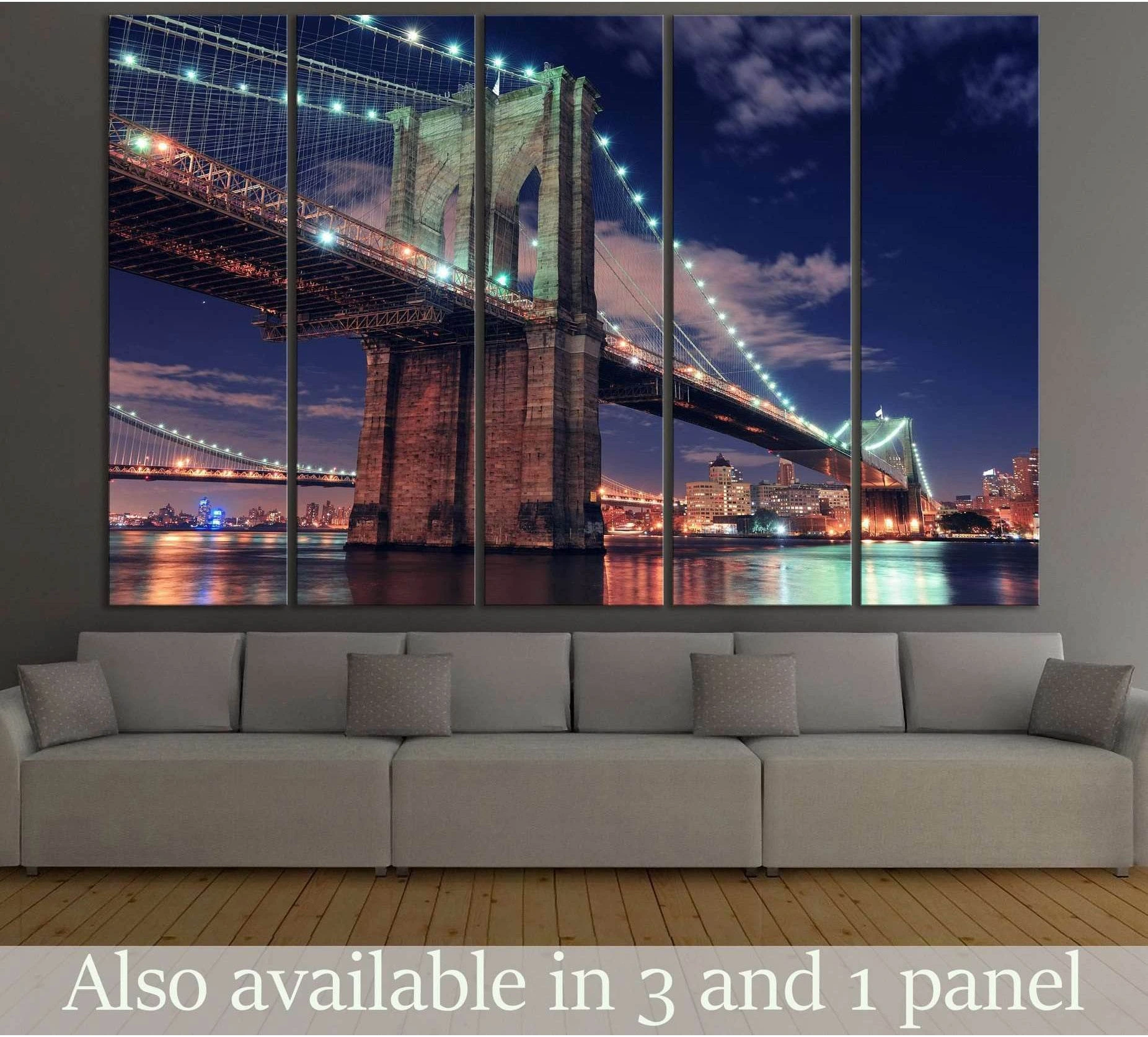 Brooklyn Bridge canvas print at night with glowing cables and river reflections, displayed above a sofa in a modern living room