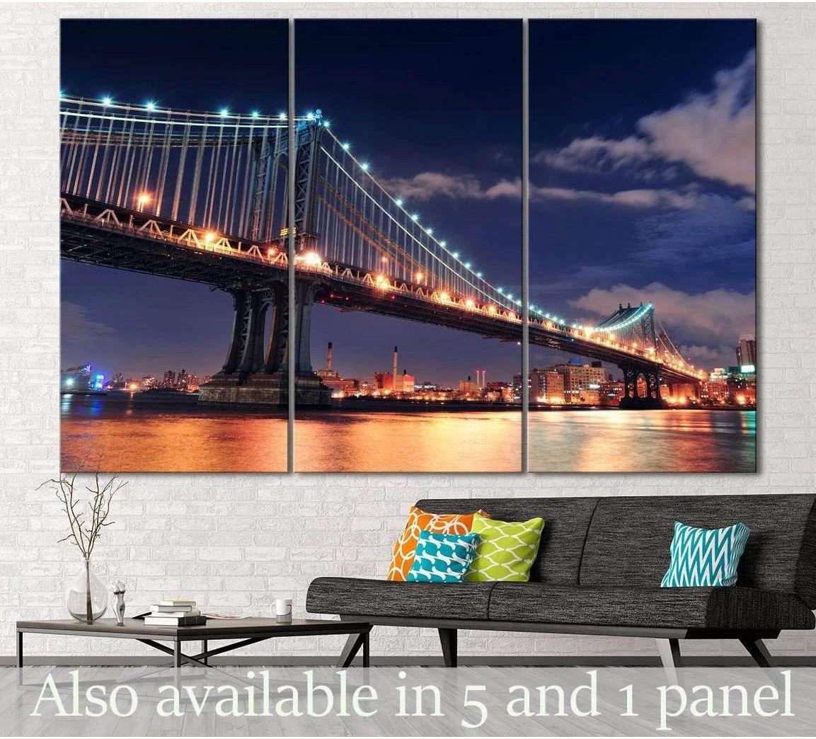 Manhattan Bridge at night triptych canvas print with blue sky and gold river reflections above a sofa