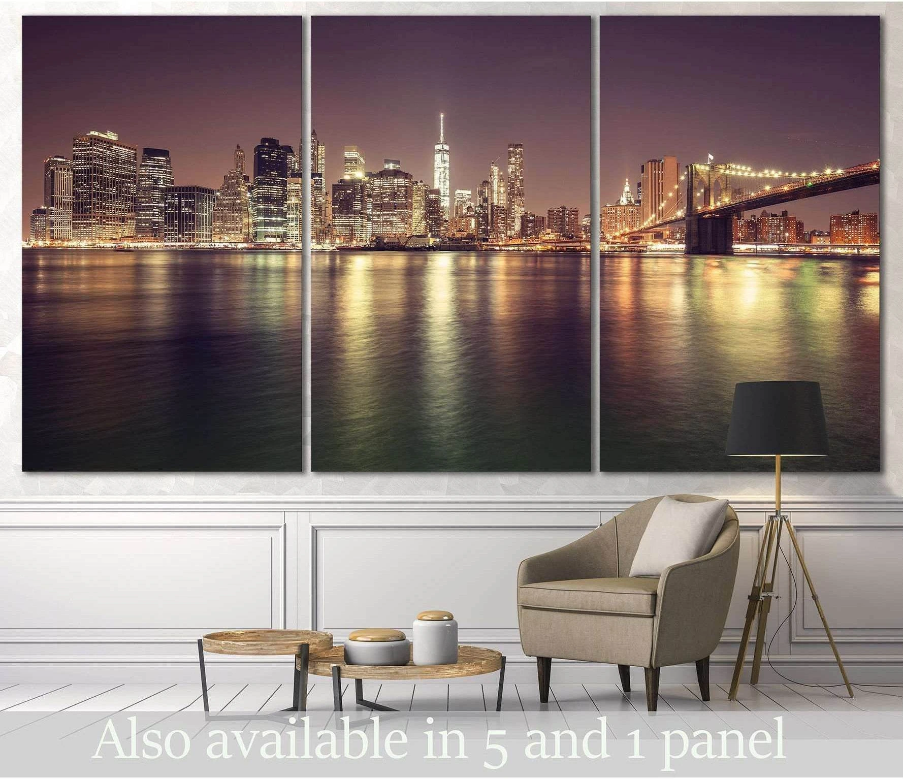 Manhattan skyline triptych canvas print with Brooklyn Bridge at night above a chair in a modern living room