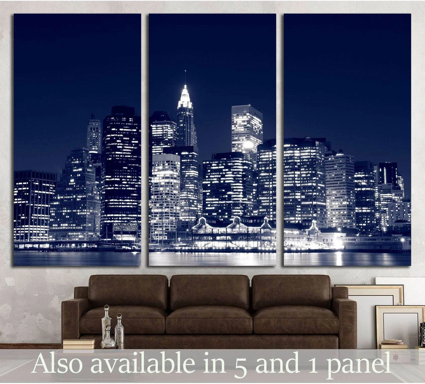 Black and white Manhattan skyline triptych canvas print above brown sofa in modern living room