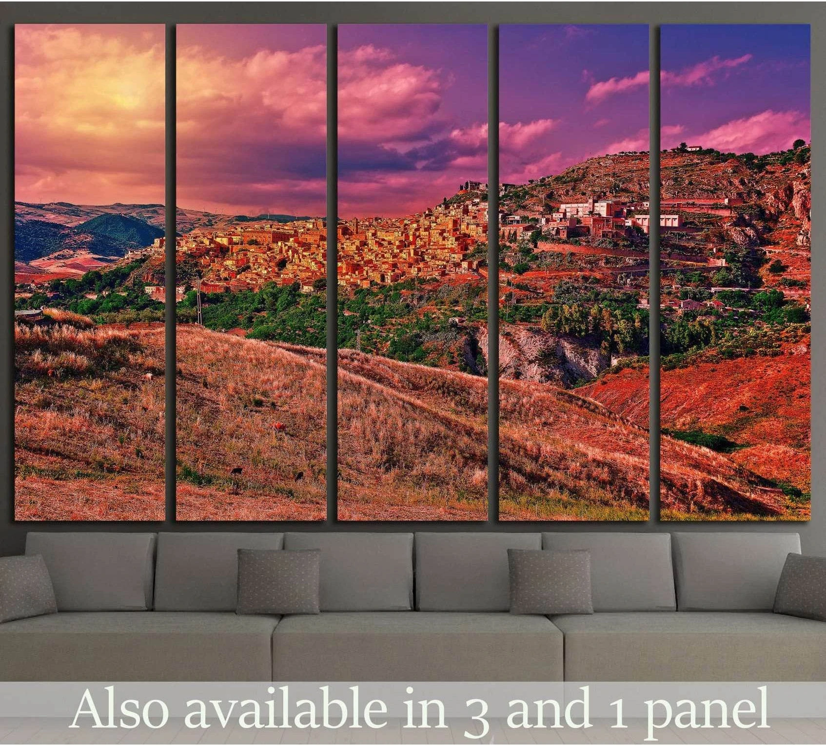 Medieval hilltop town canvas print in warm sunset tones above a sofa in a modern living room