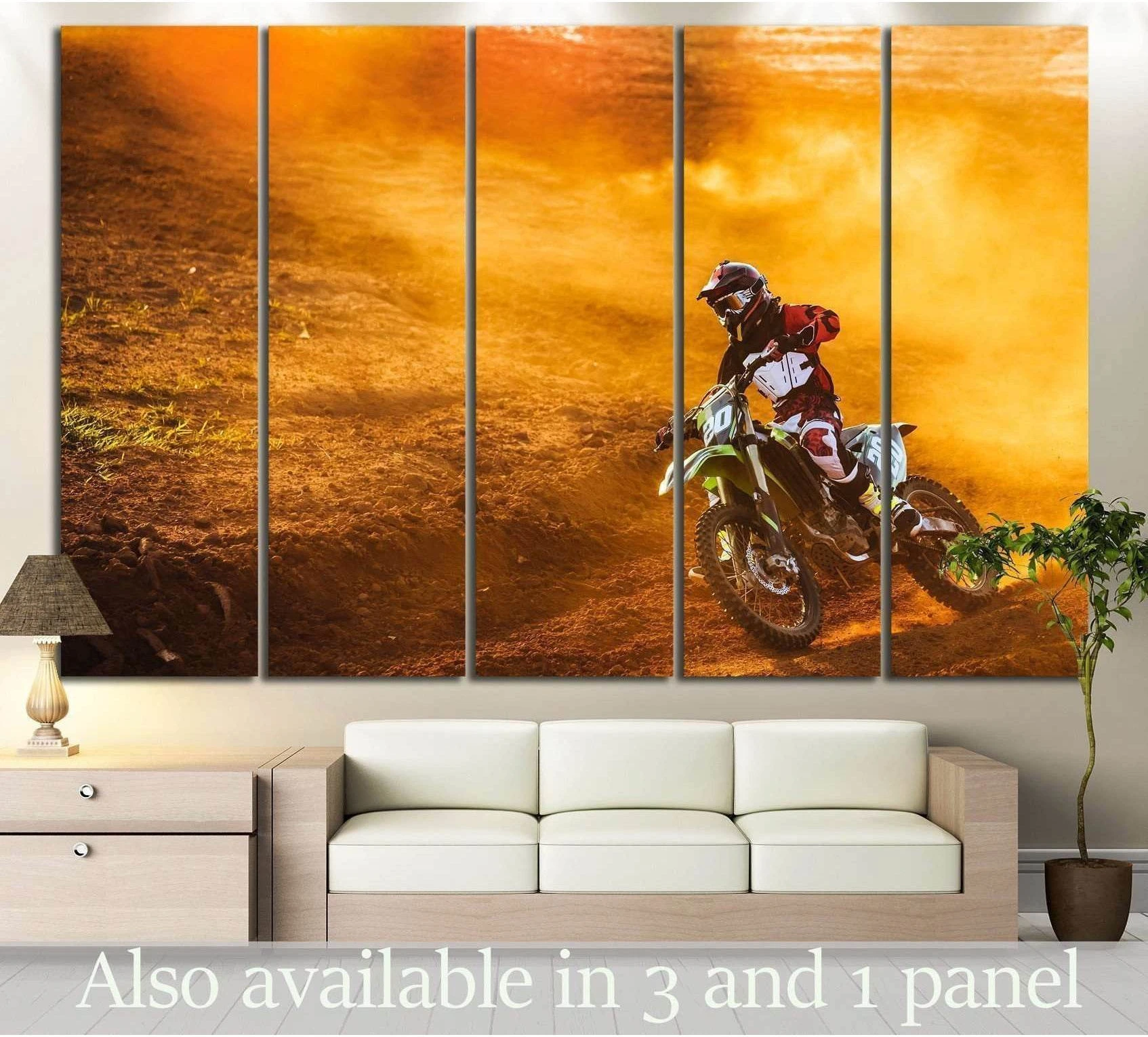 Motocross canvas print with a dirt bike rider carving through orange dust, displayed above a sofa in a modern living room