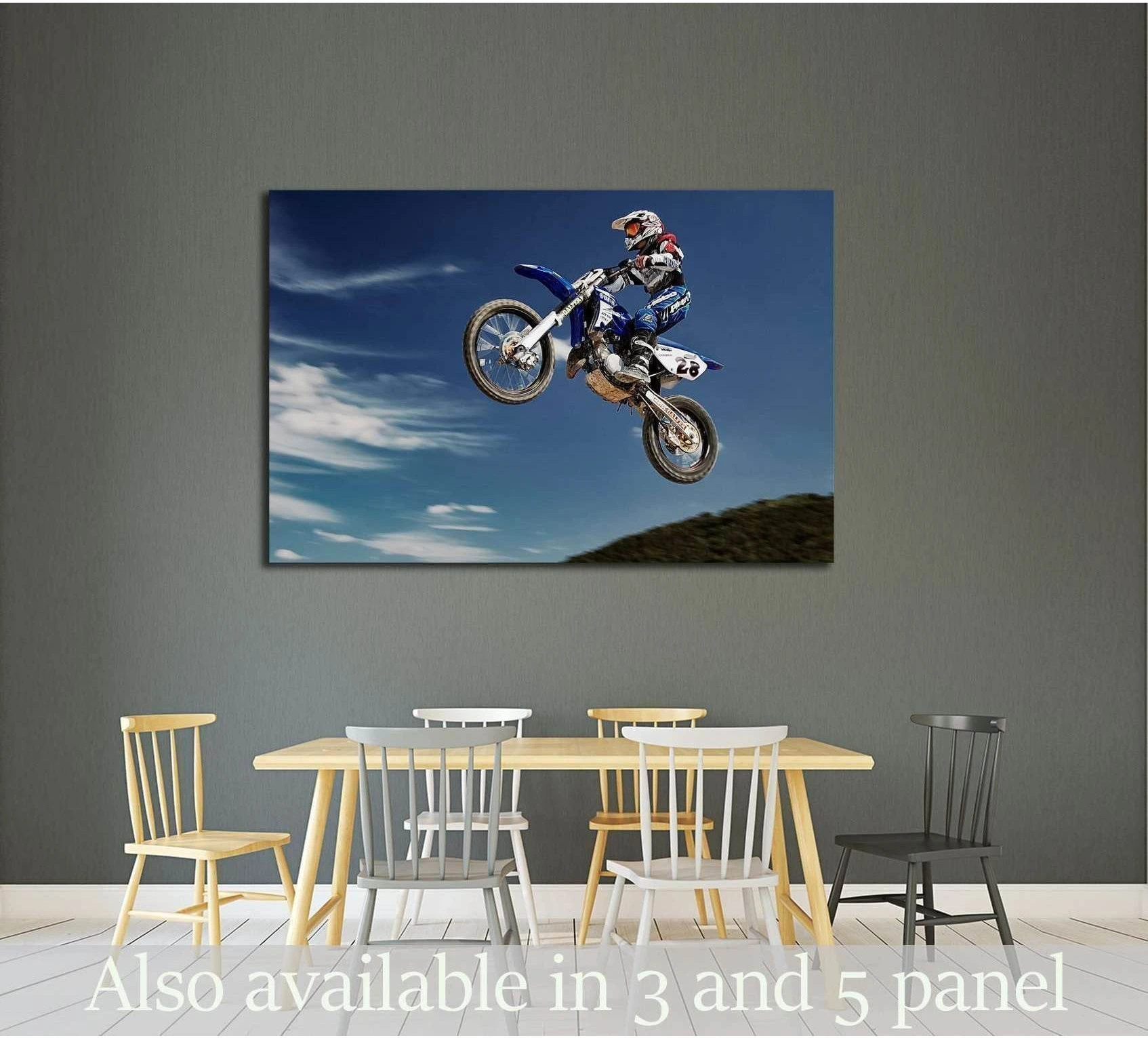Motocross canvas print with dirt bike rider mid-jump against blue sky above dining room table