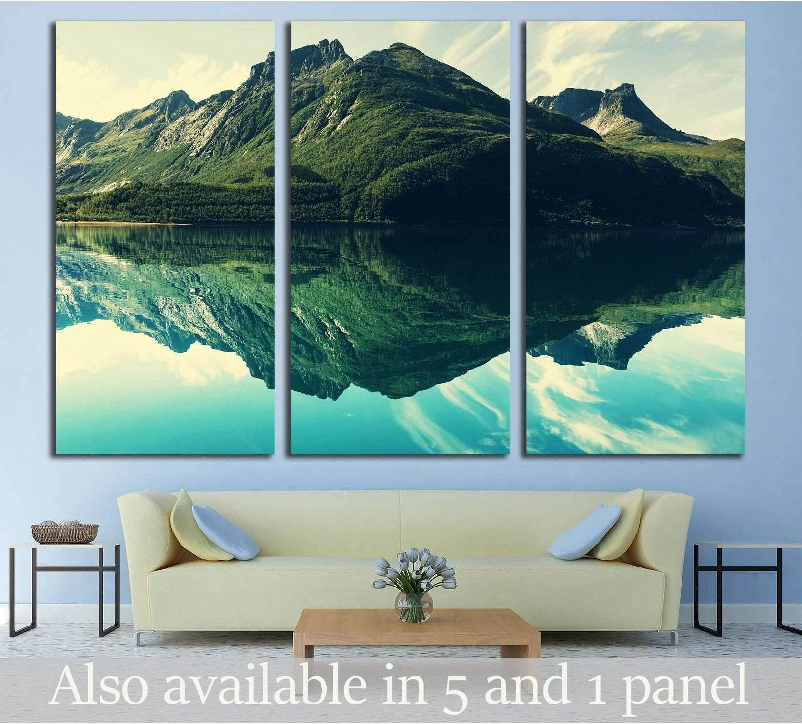 Triptych mountain lake canvas print with mirrored green peaks and teal water above a sofa