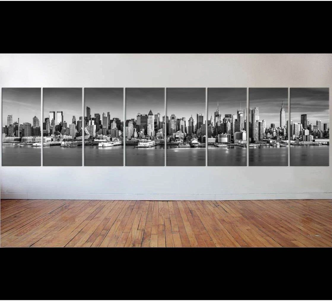 Black and white New York City skyline multi-panel canvas print displayed on a wall in a gallery-style room