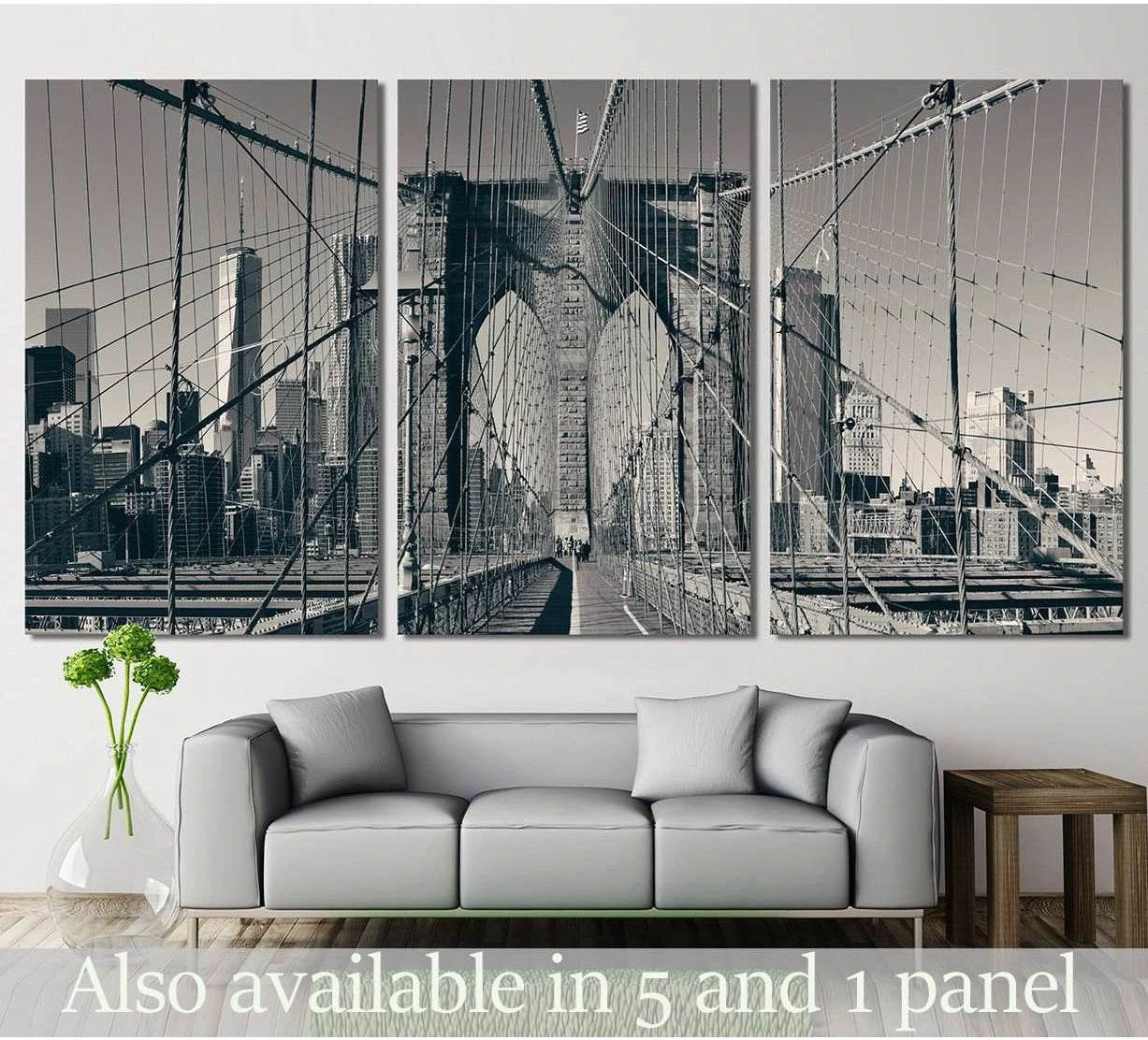 A black and white photograph of the New York City skyline and the Brooklyn Bridge