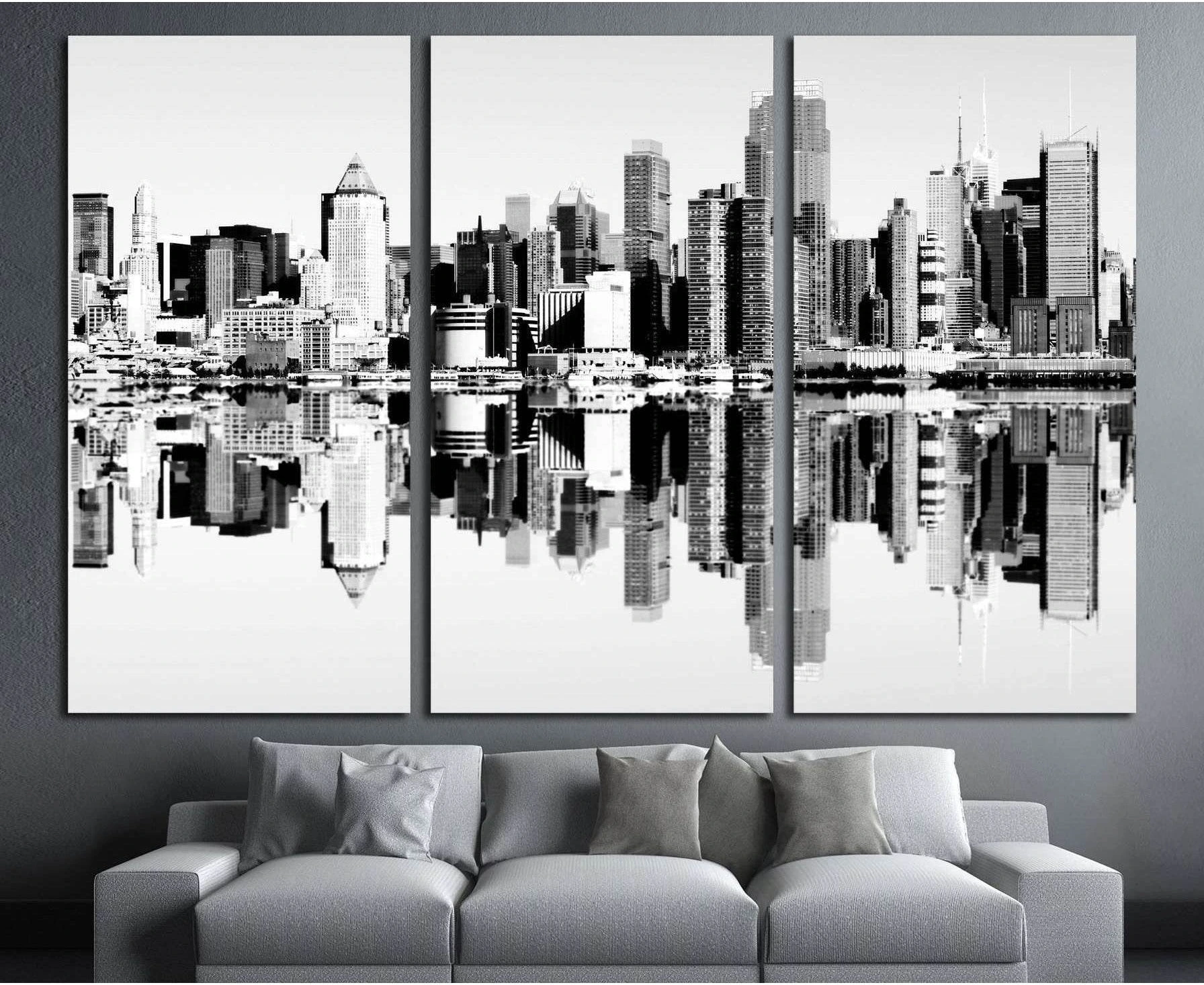 Black and white NYC skyline triptych canvas print with mirrored reflection above a gray sofa