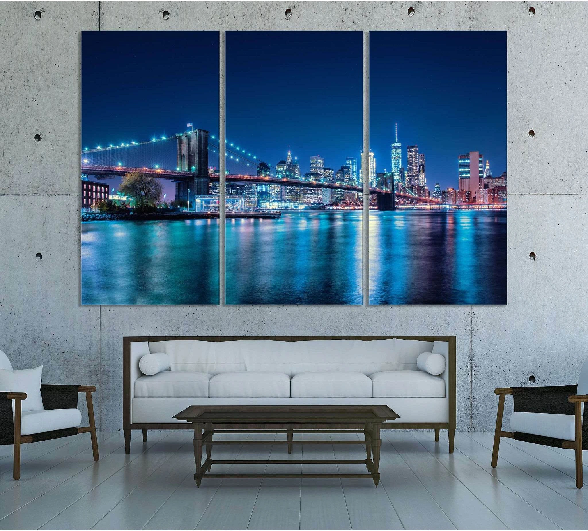 Brooklyn Bridge canvas print with blue NYC skyline at night in a modern living room triptych mockup