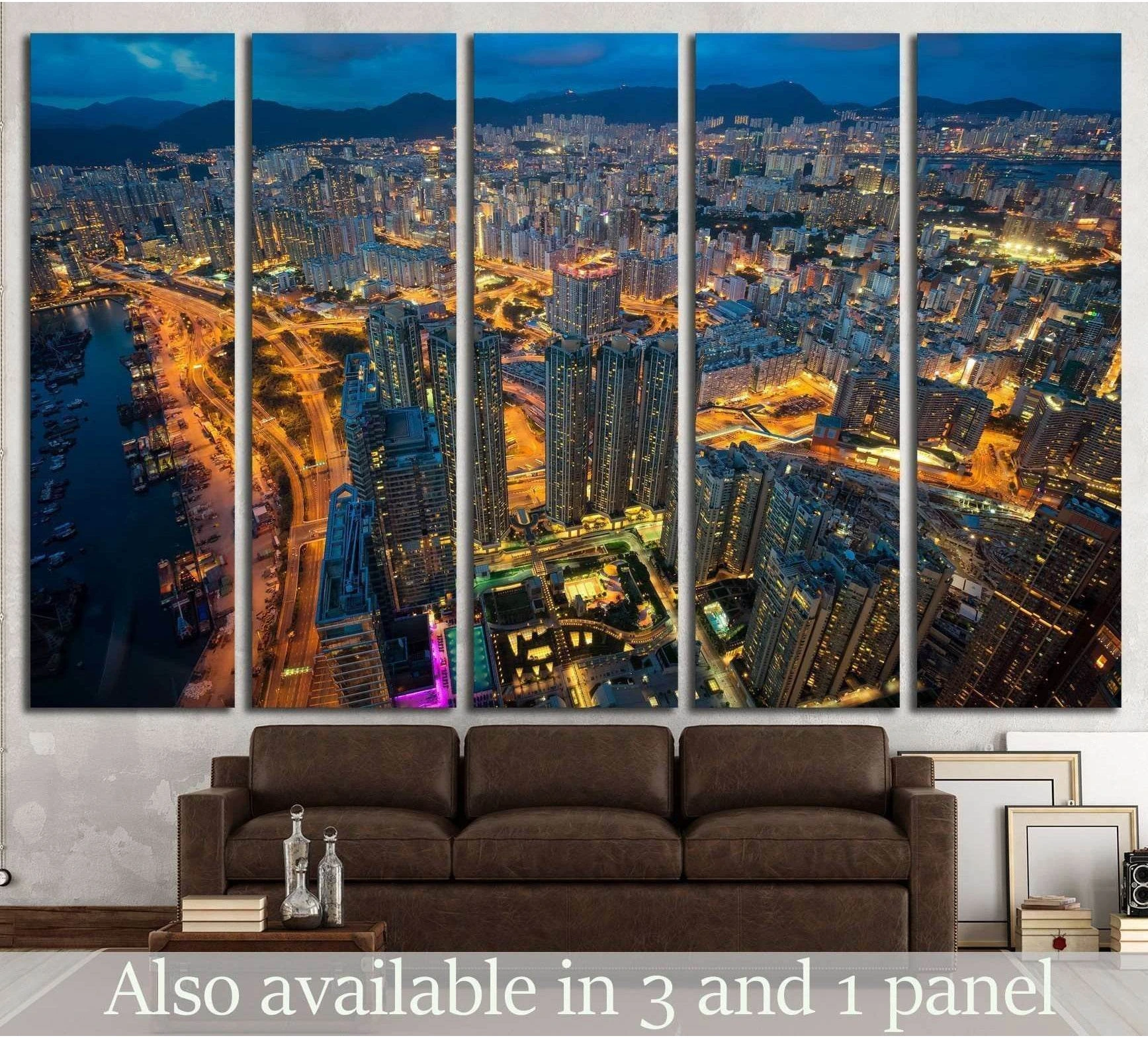 Aerial night city canvas print in five panels above a sofa with glowing roads and blue dusk skyline