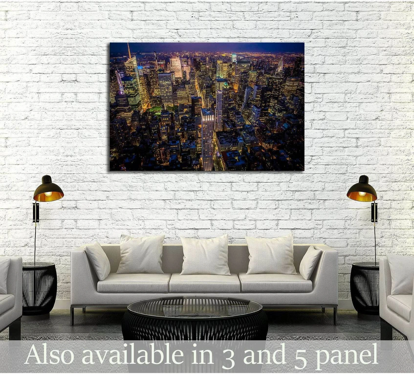 Manhattan skyline canvas print at night displayed above a sofa in a modern living room