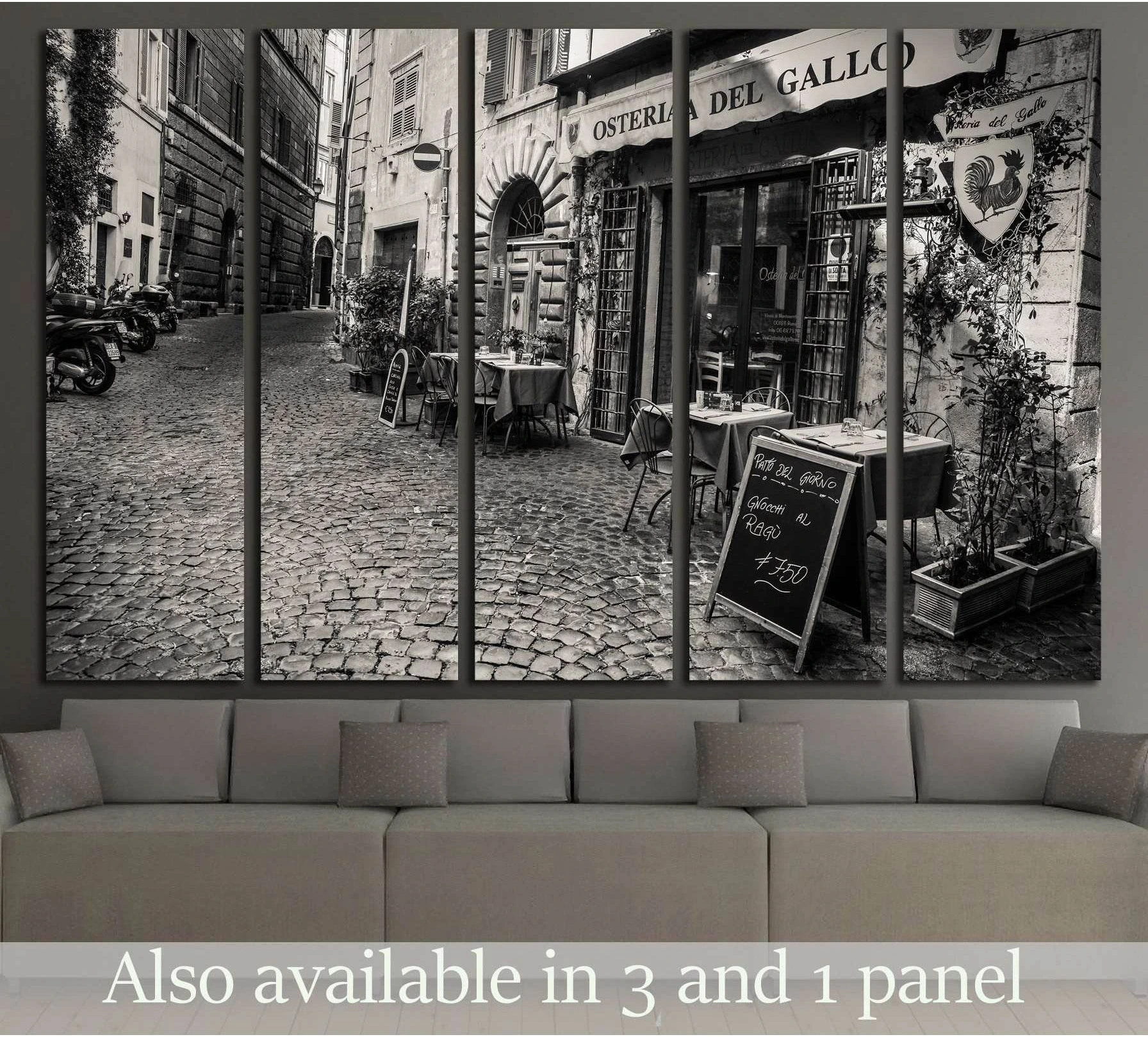 Black and white Rome street canvas print with cobbled lane and osteria, displayed above a sofa in a modern living room