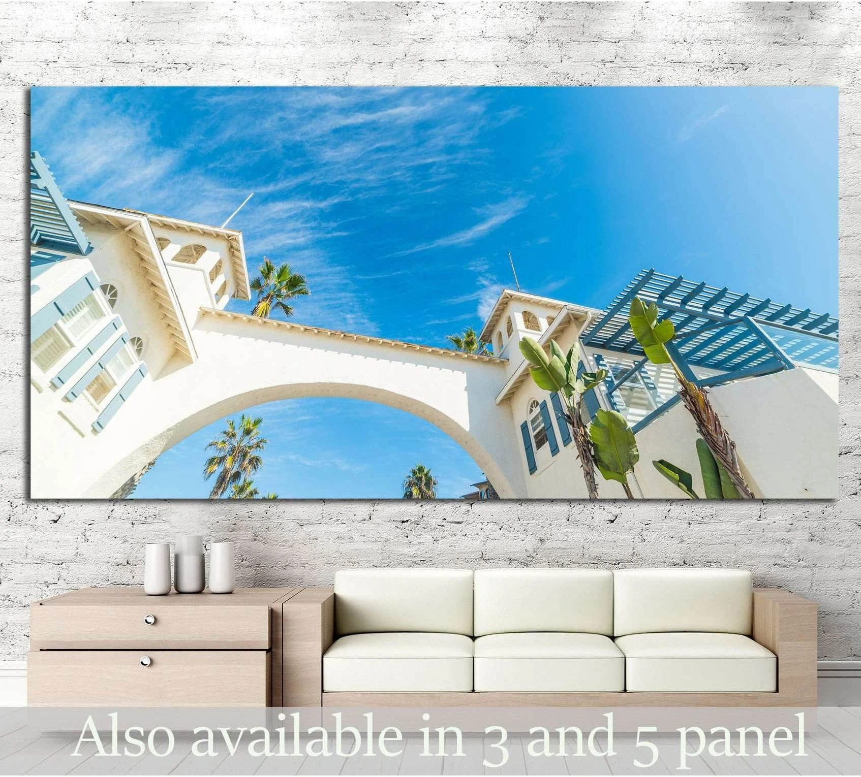 White coastal arch and palm trees Pacific Beach canvas print above sofa in a bright living room
