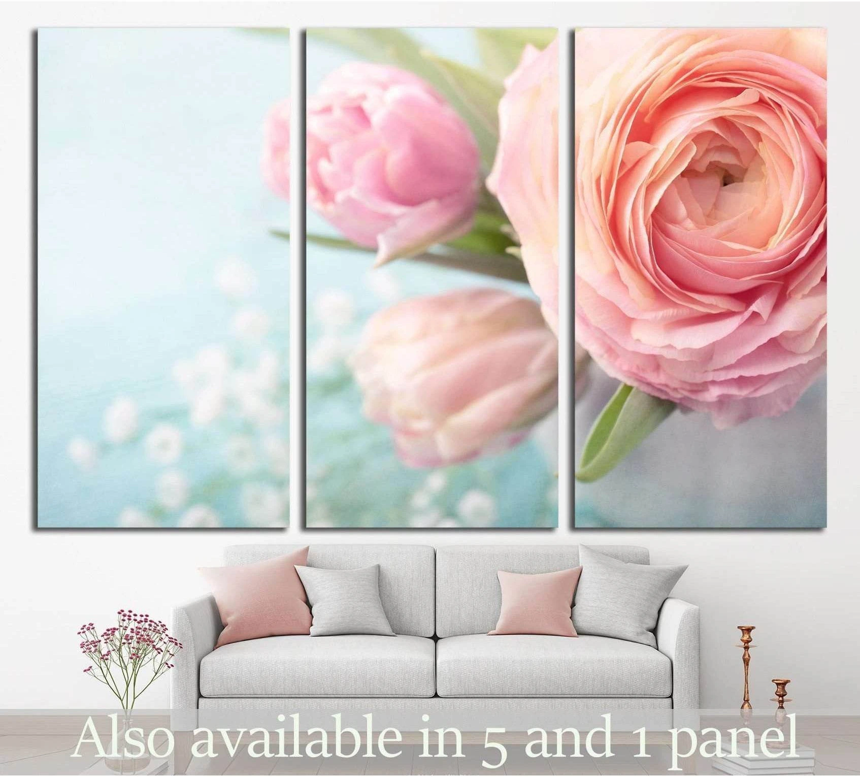 Pink flower triptych canvas print with soft blush blooms above a sofa in a pastel living room