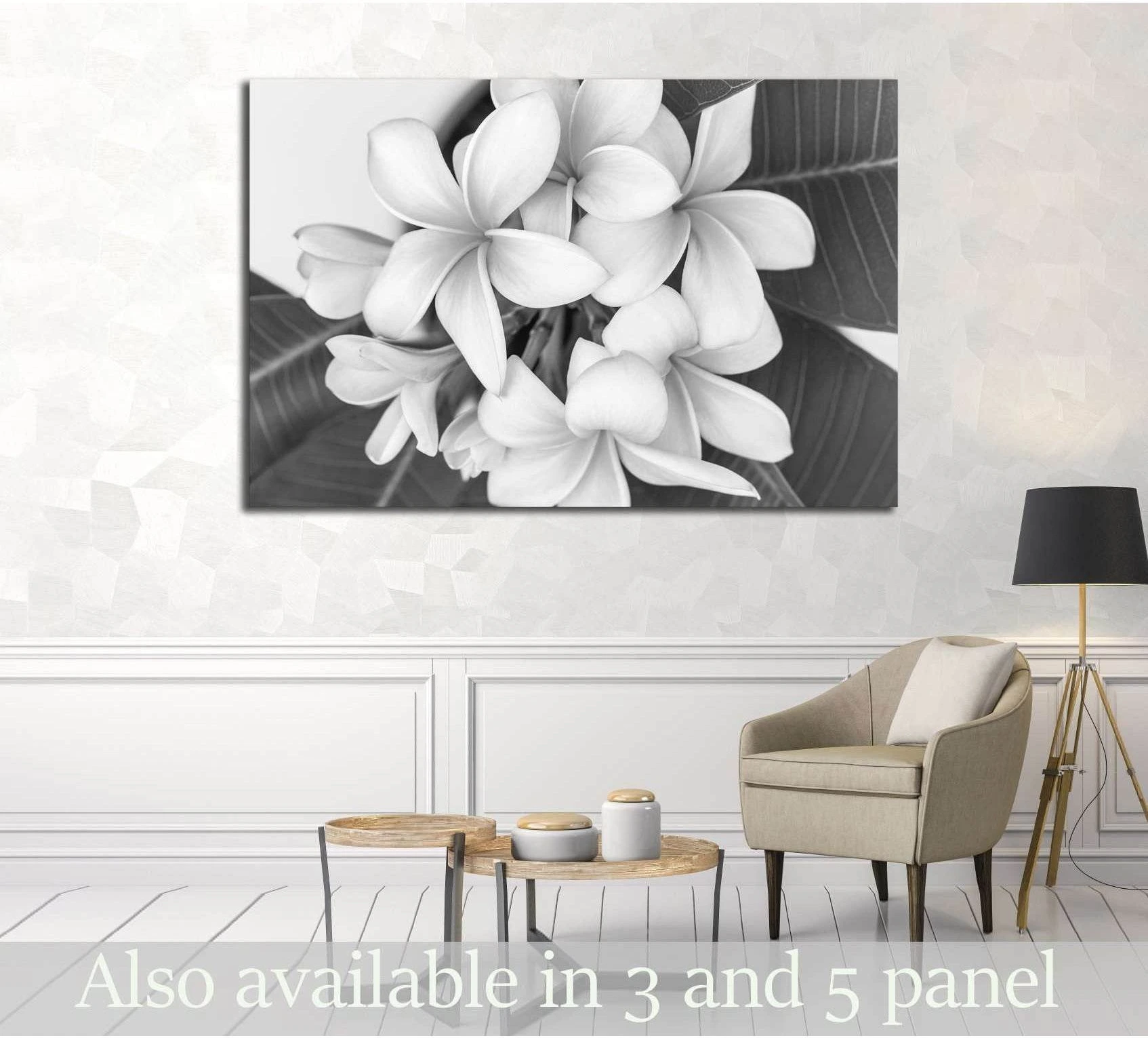 Black and white plumeria flower canvas print displayed above chair in a neutral living room